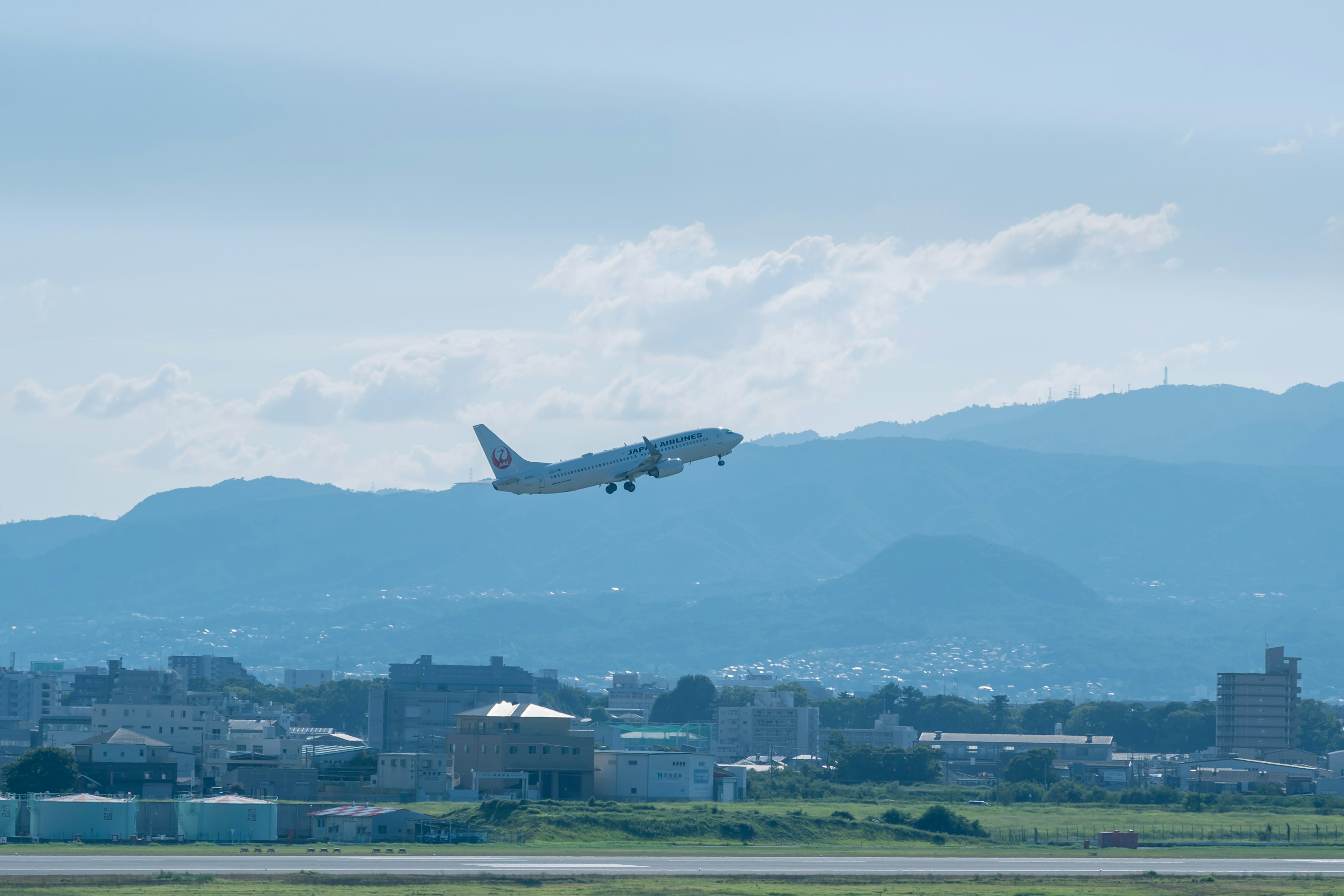 Aereo in fase di decollo con sfondo di cielo blu e montagne