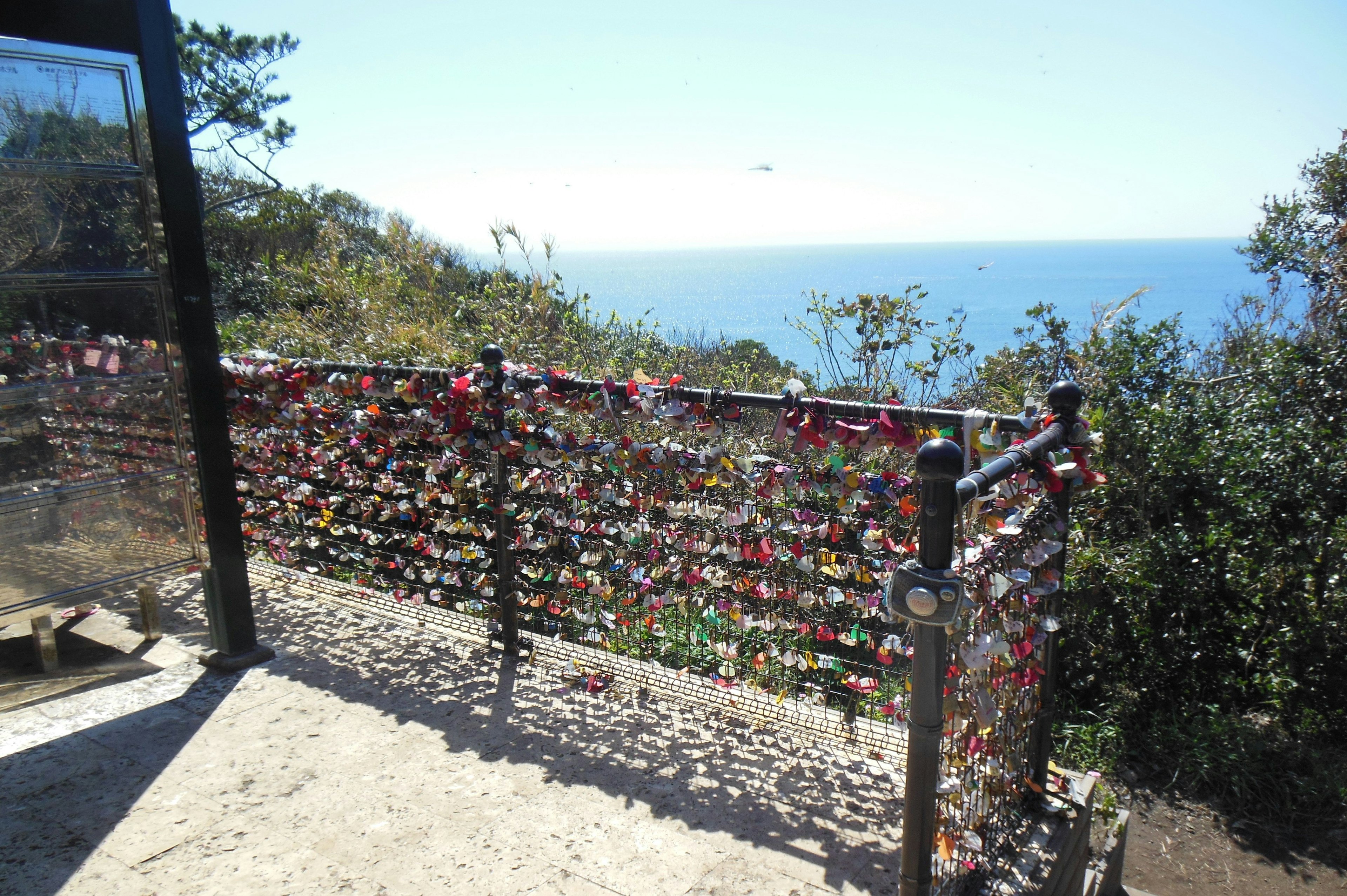 Fence adorned with love locks overlooking the ocean