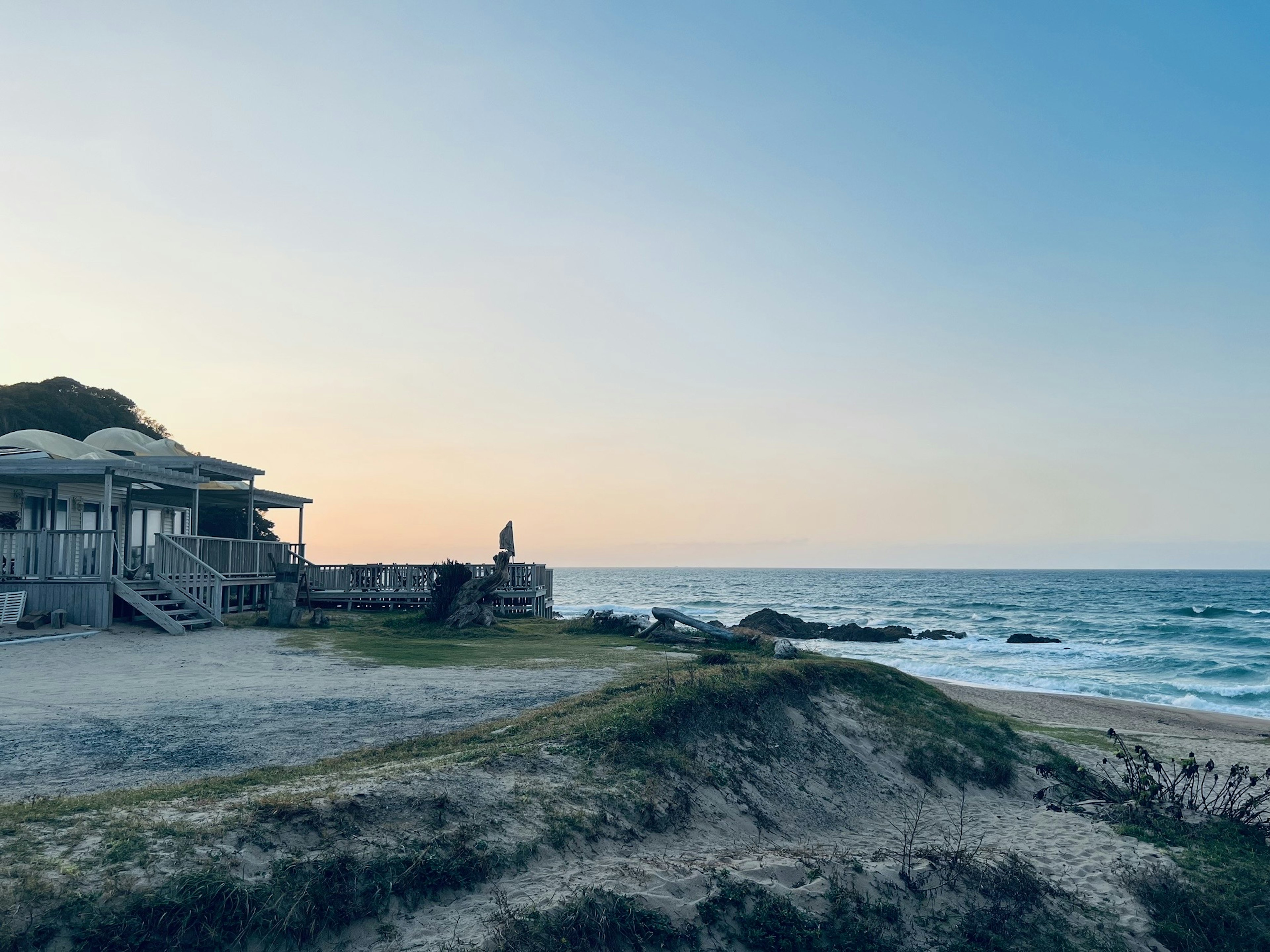 Coastal scene with a small house and calm ocean