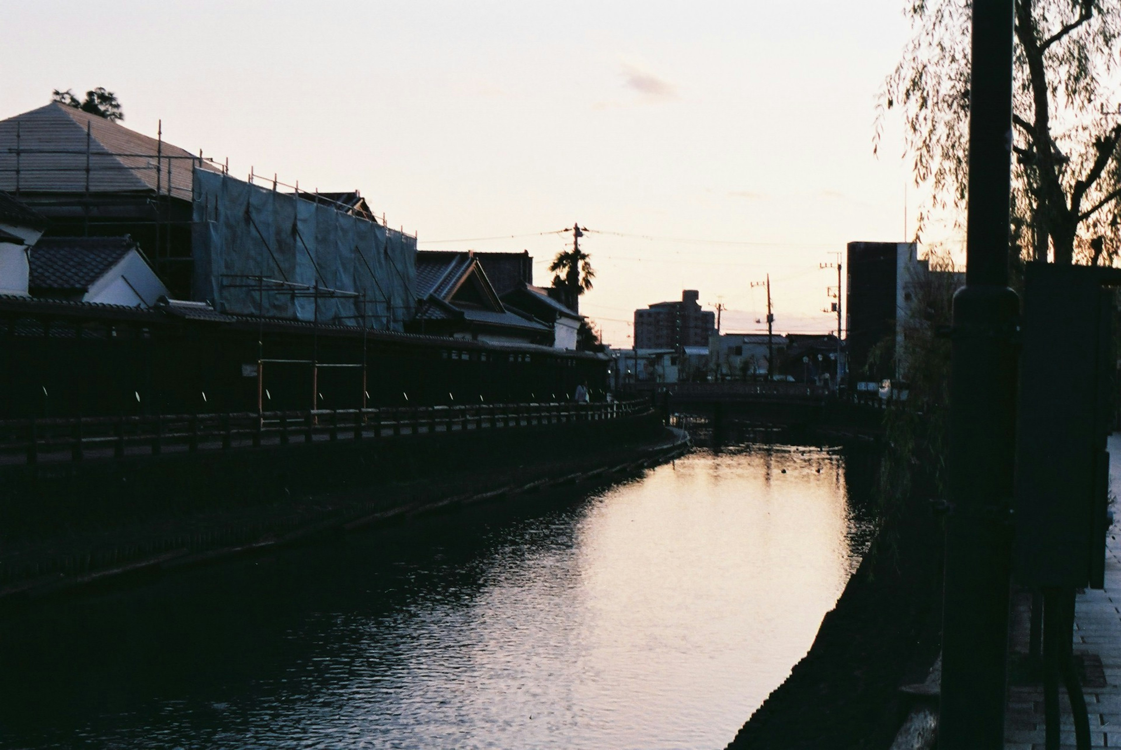 夕暮れ時の川沿いの風景と建物のシルエット