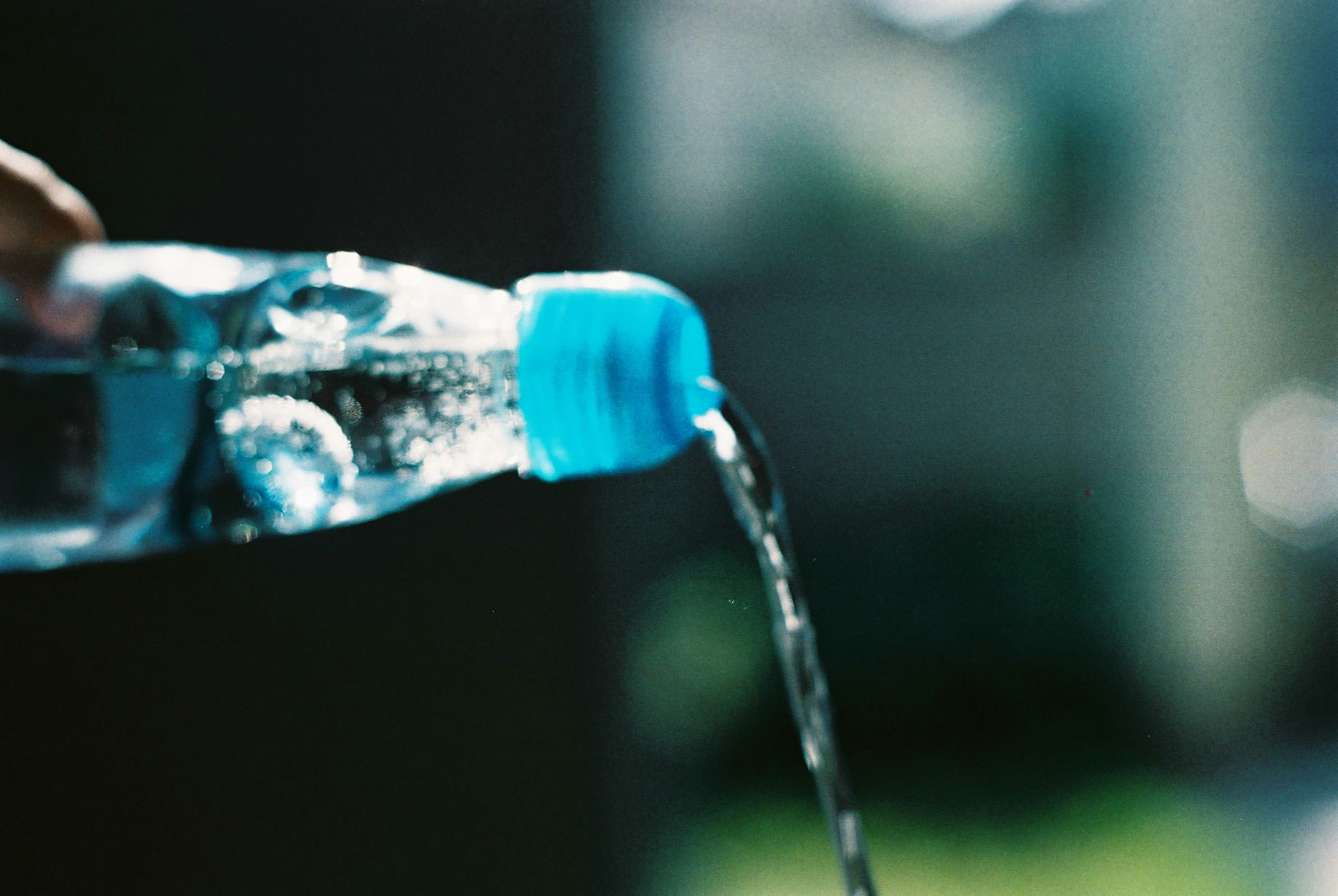 Water pouring from a blue-capped bottle