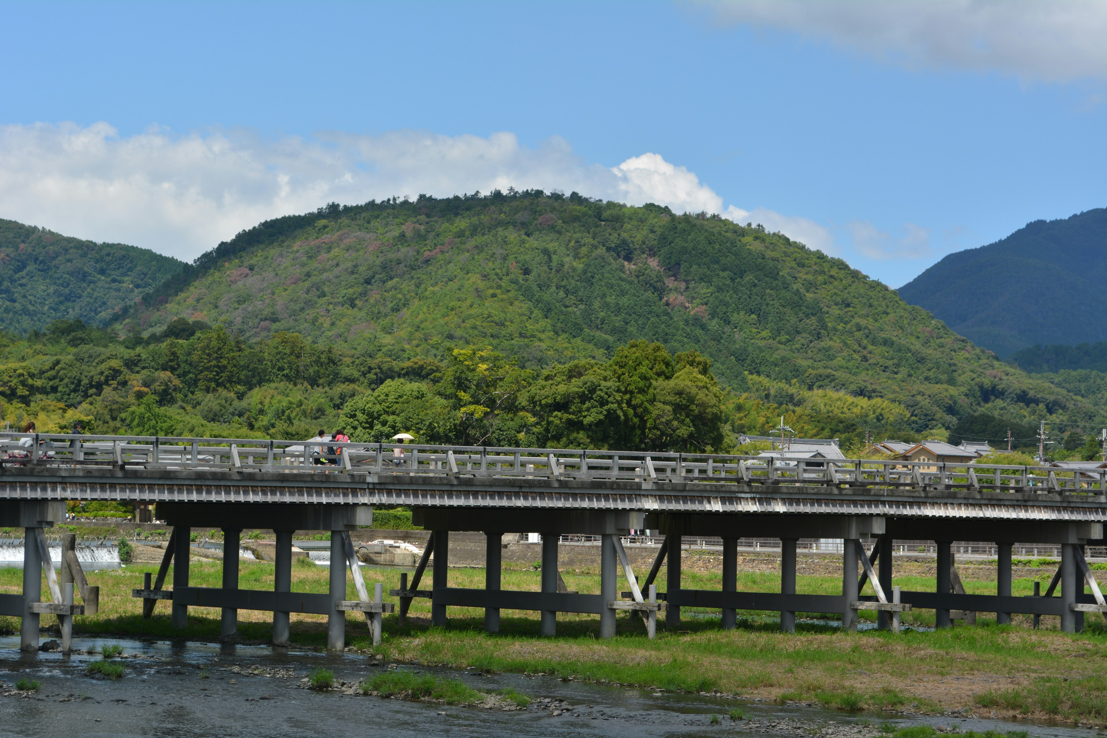 Scenic view of an old bridge with lush green hills in the background