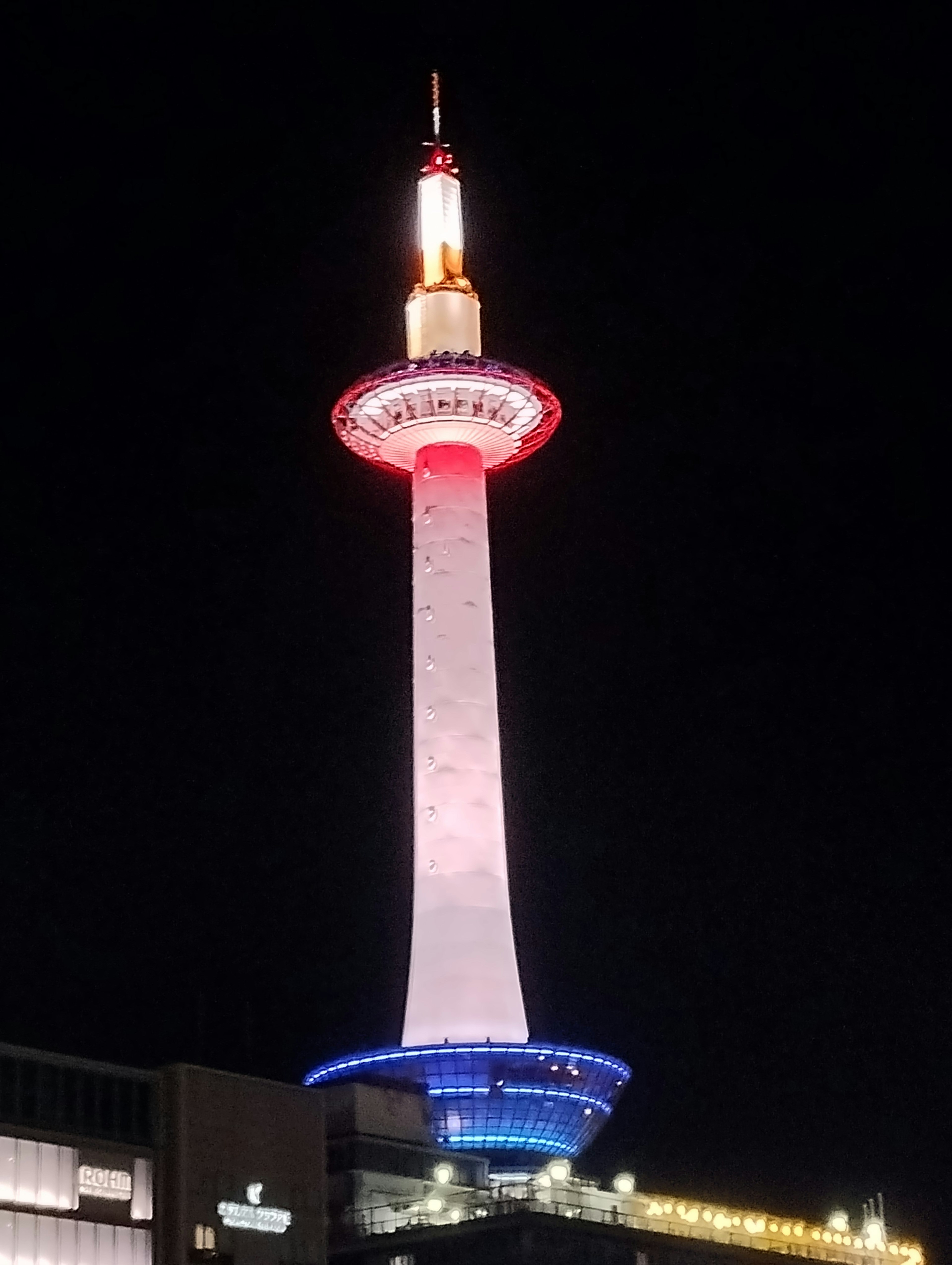 Illuminated Kyoto Tower at night with colorful lights