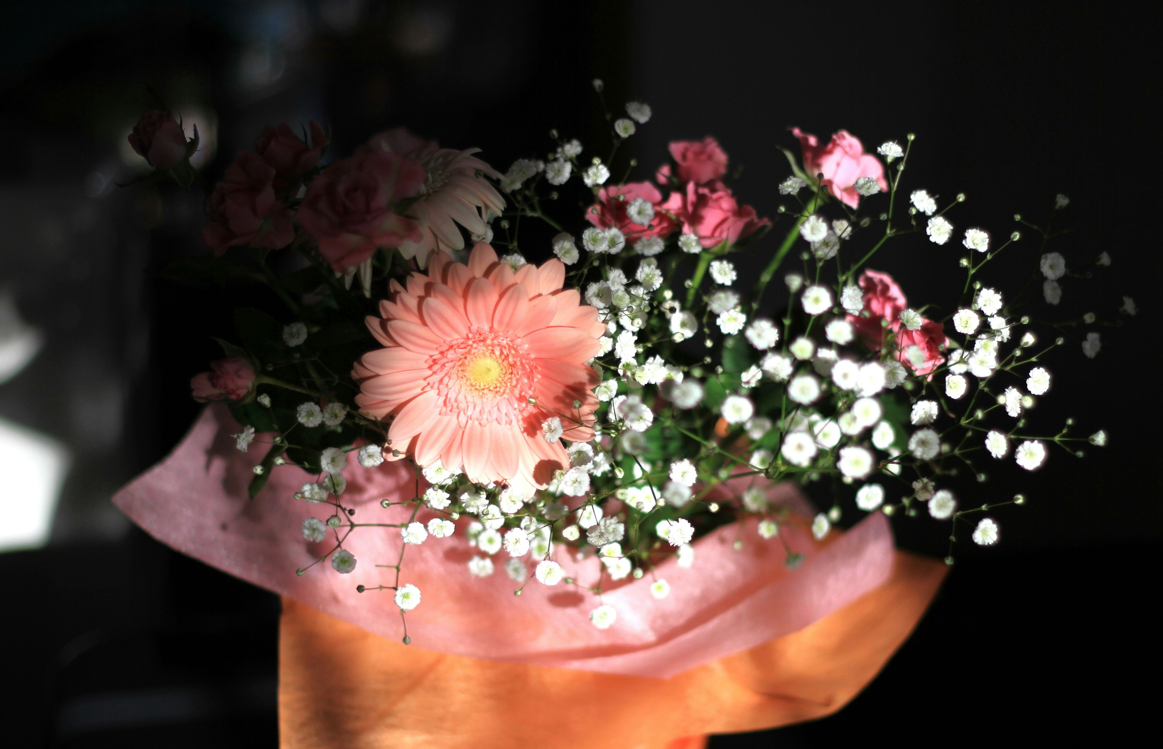 Primo piano di un bouquet con fiori rosa e gipsophiles