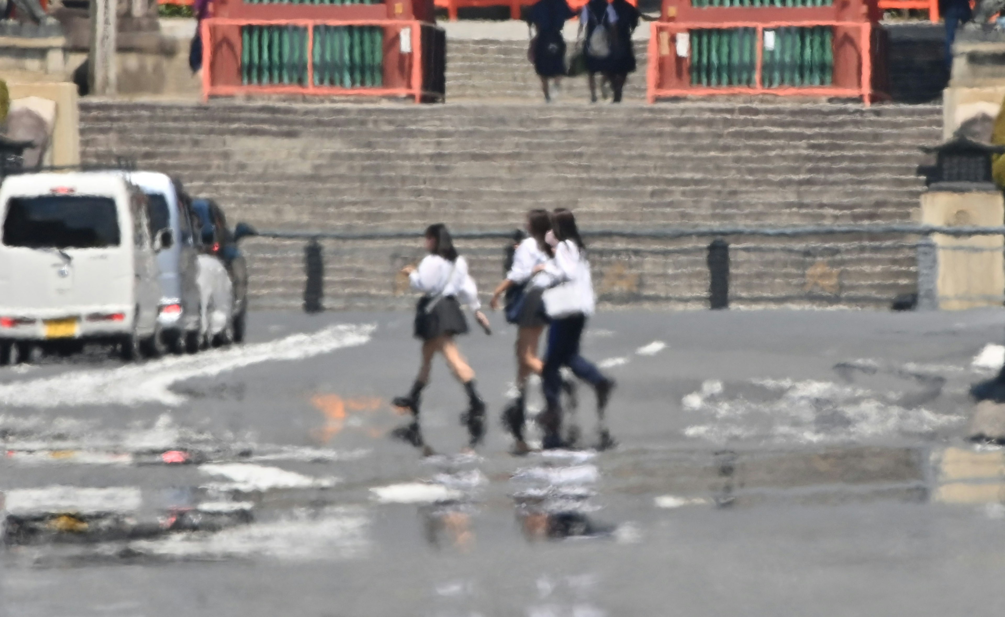 学生たちが通りを横断している風景背景には階段と建物がある