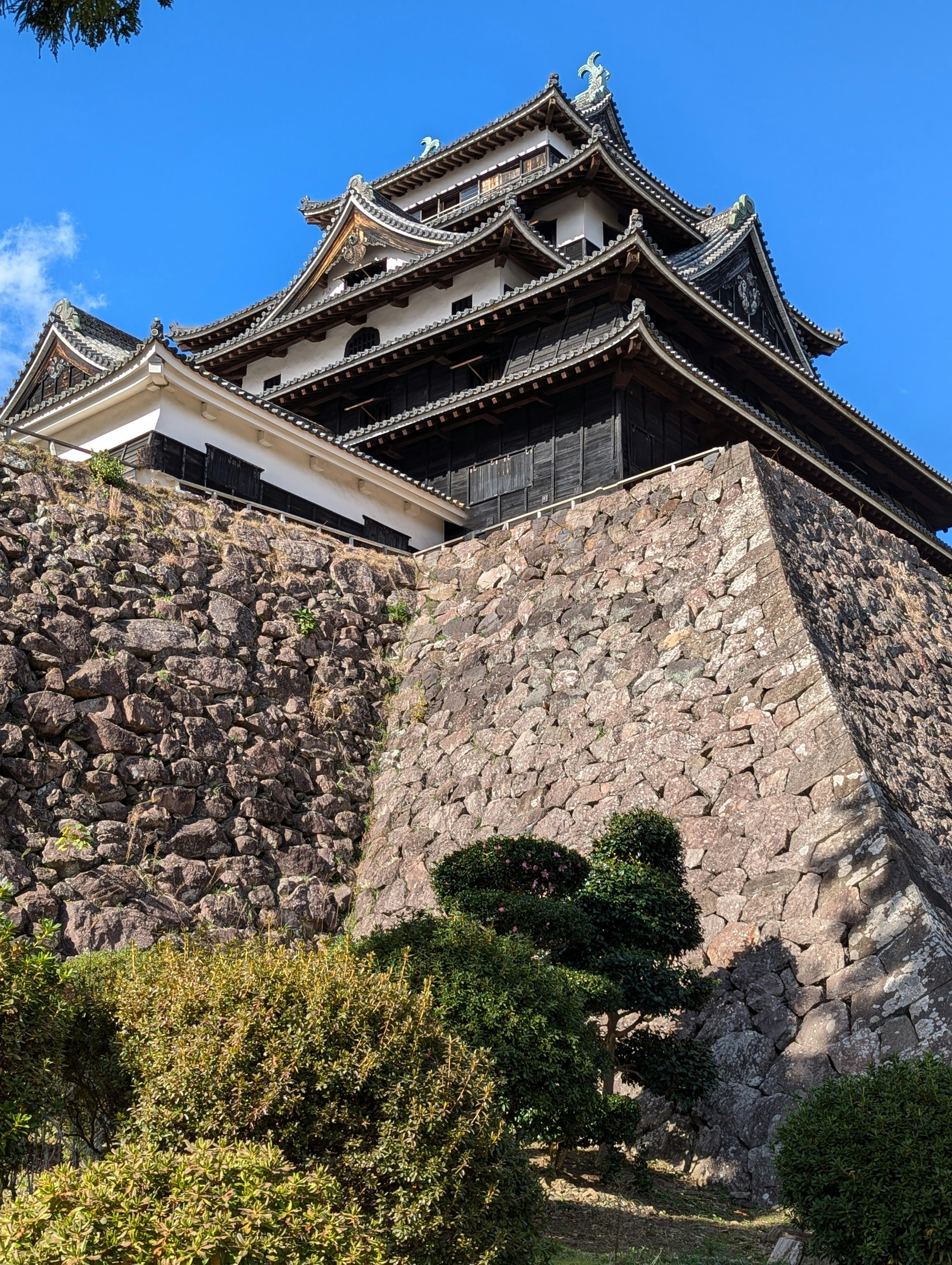 Foto eines japanischen Schlosses mit Steinmauern und traditioneller Dacharchitektur