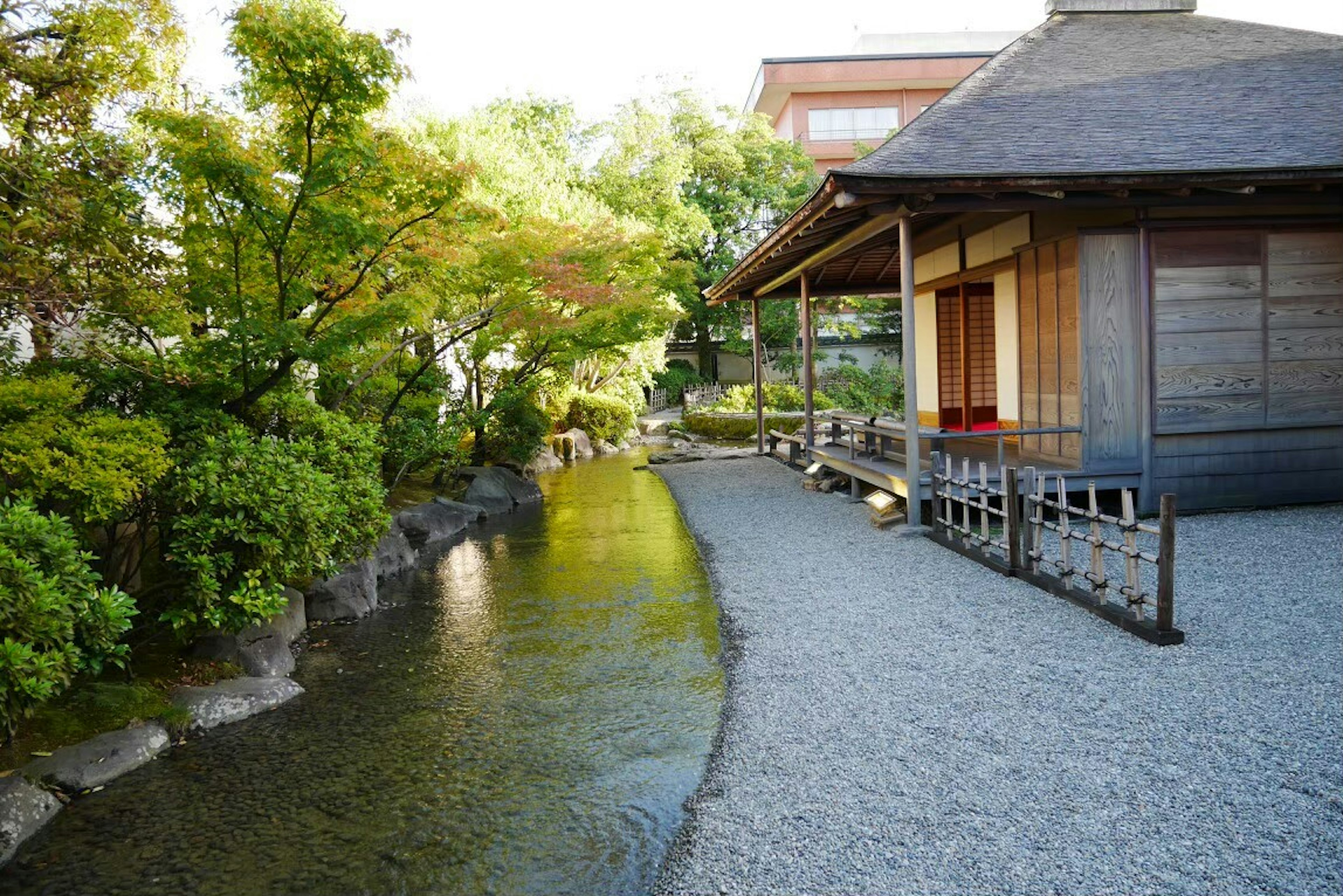 Jalan taman Jepang yang tenang dengan rumah kayu dan aliran