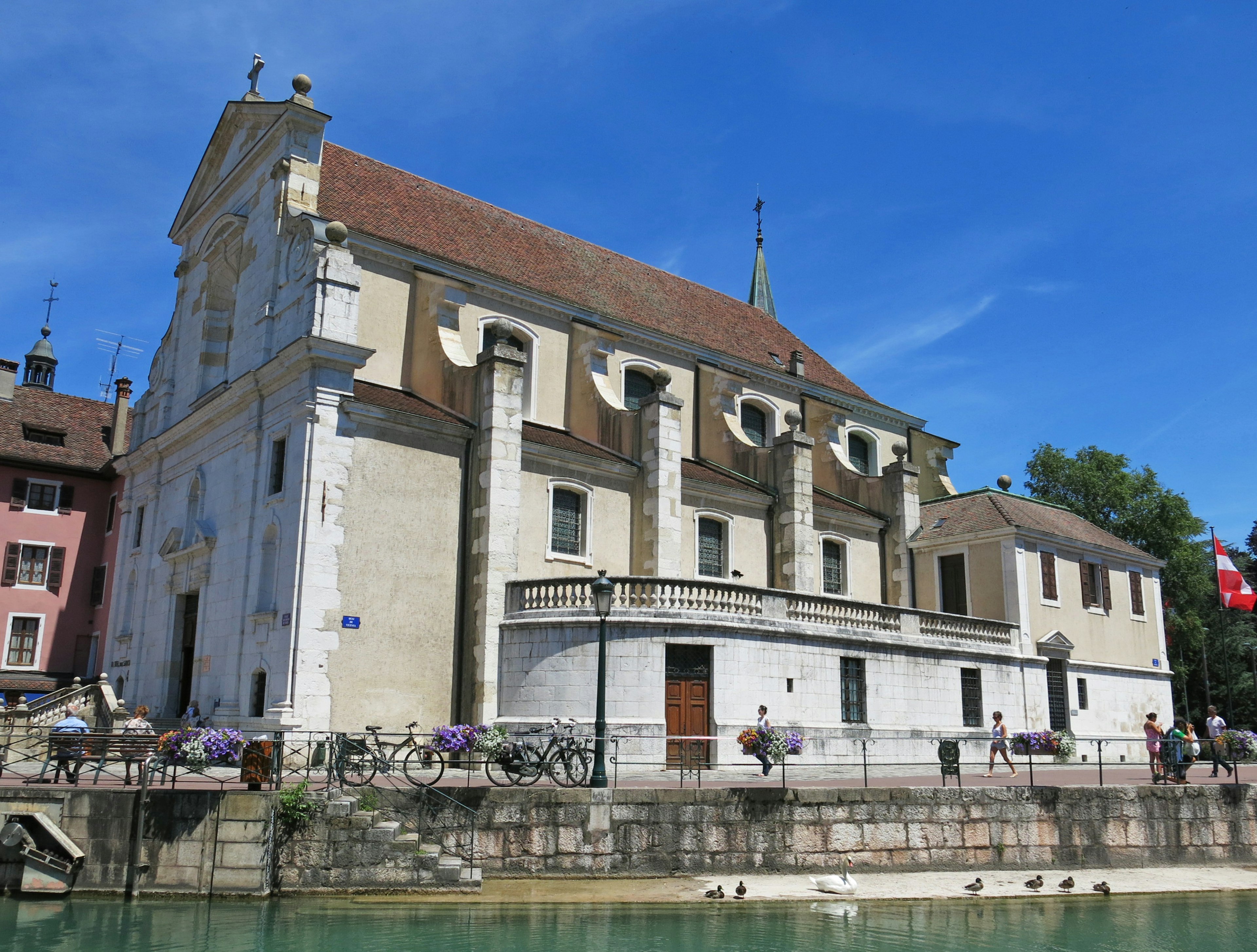 Historical building beside a river under a clear blue sky