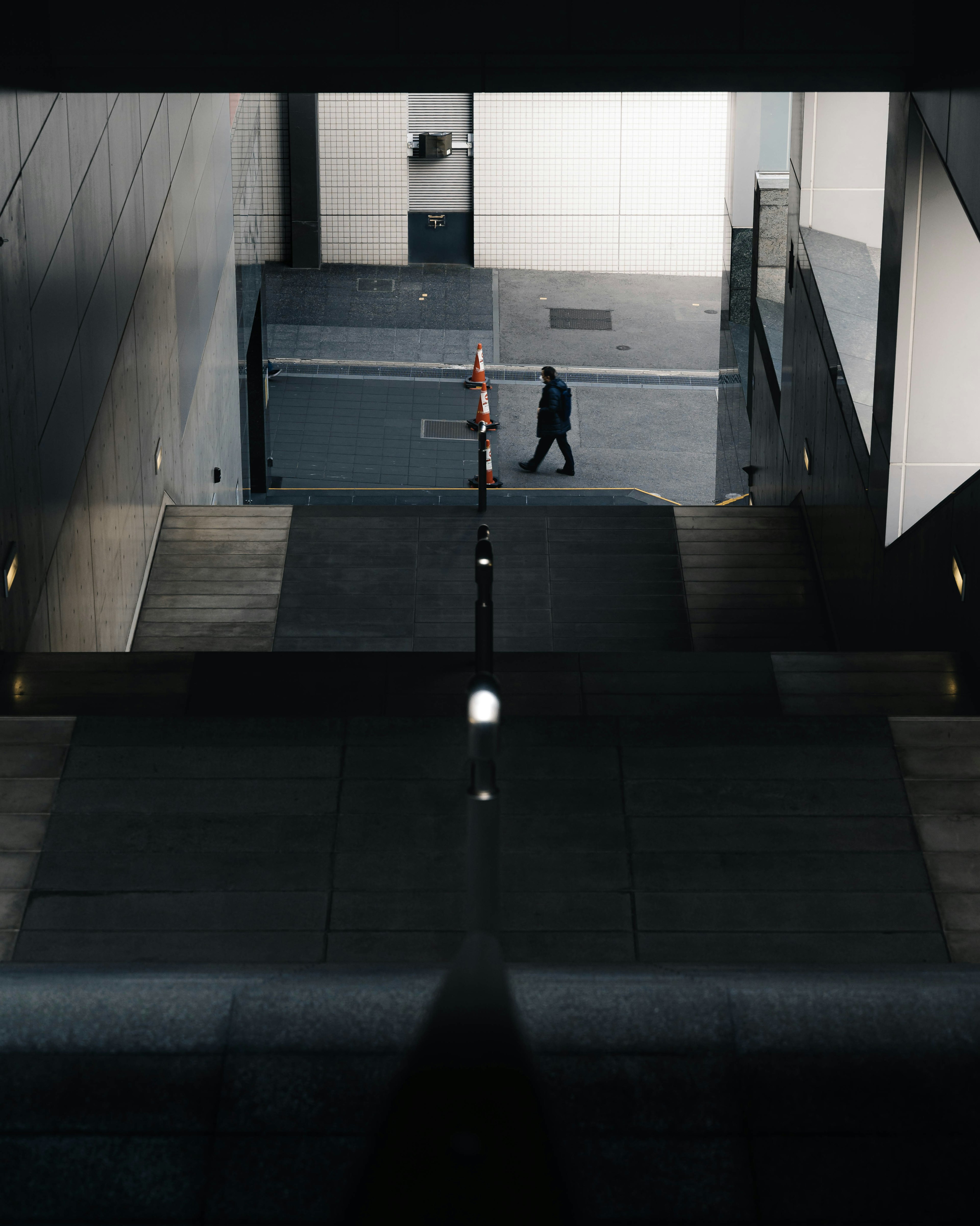 Silhouette of a person walking down stairs with modern architectural elements