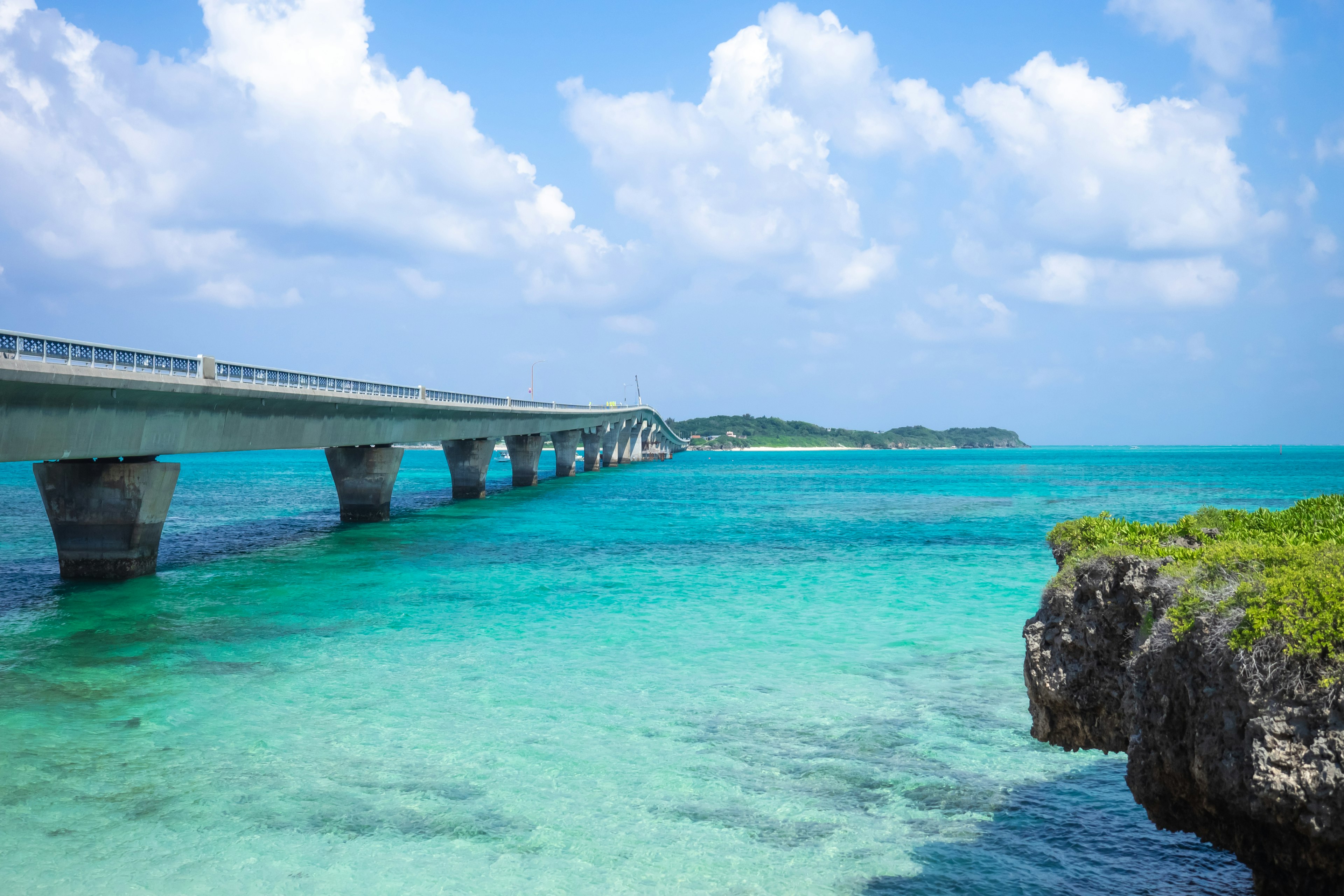 Vista escénica de un océano azul con un puente que se extiende sobre el agua