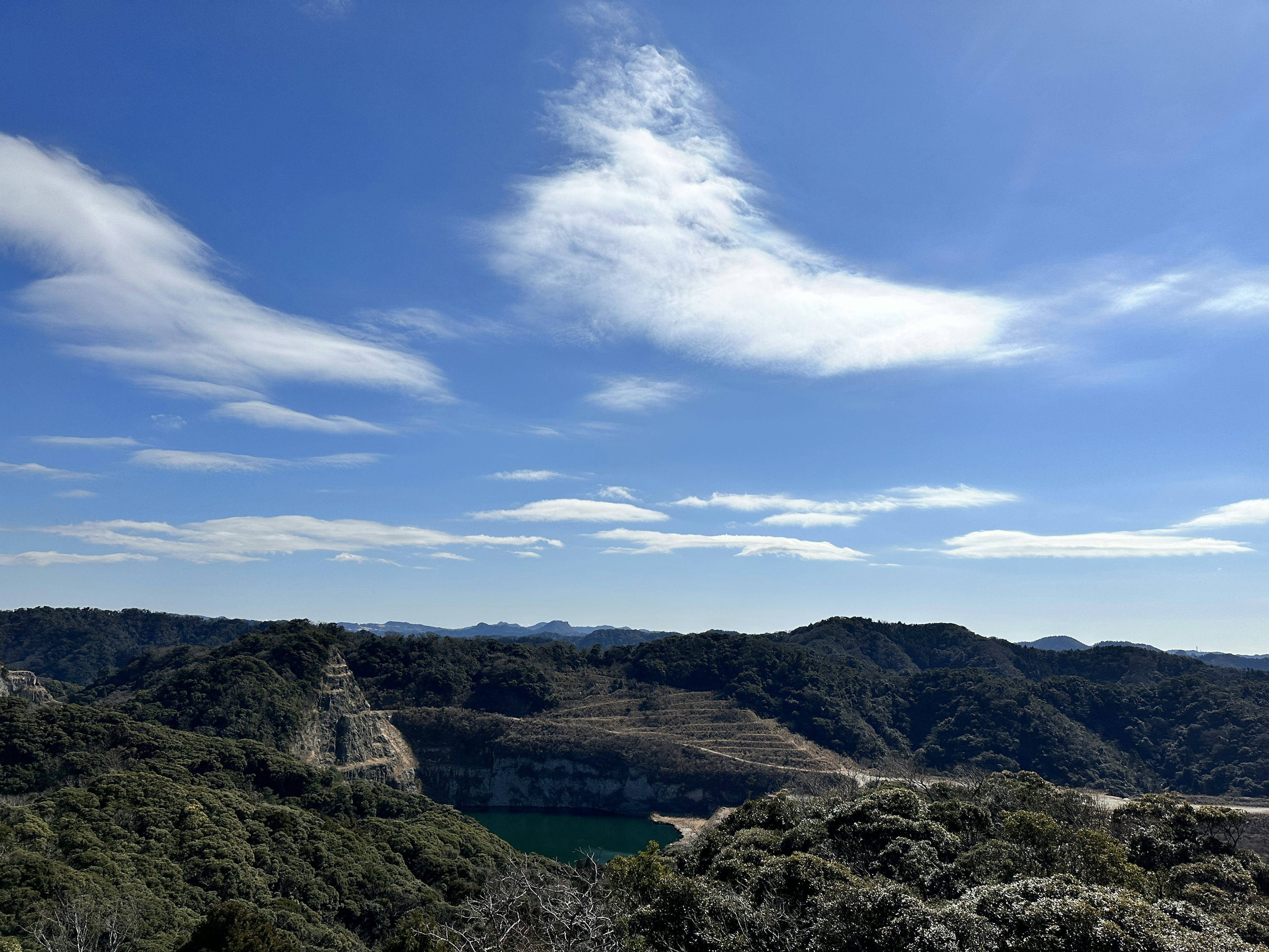 Pemandangan pegunungan luas dan langit biru dengan danau tenang terlihat