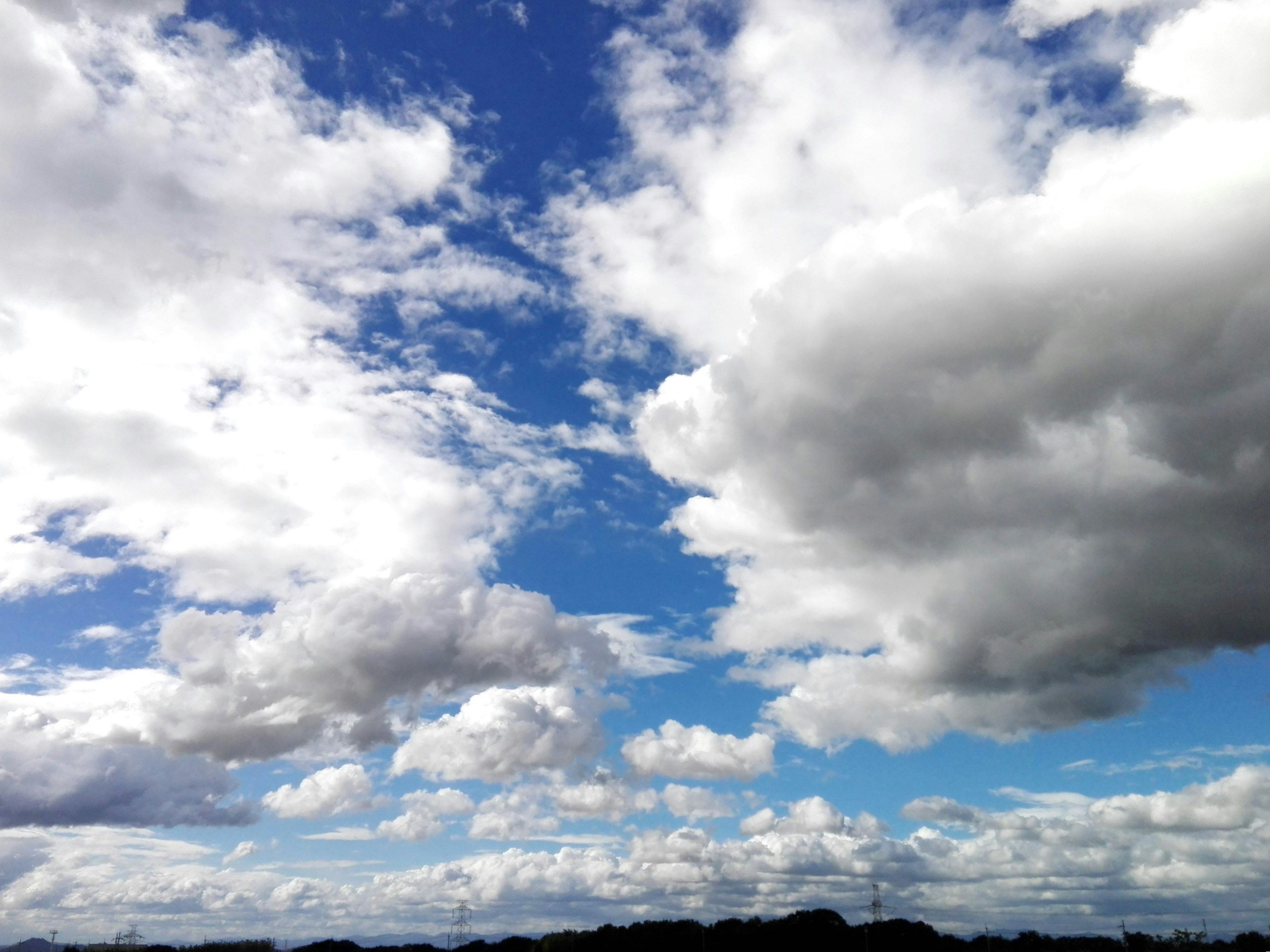 Expansive blue sky with fluffy white clouds