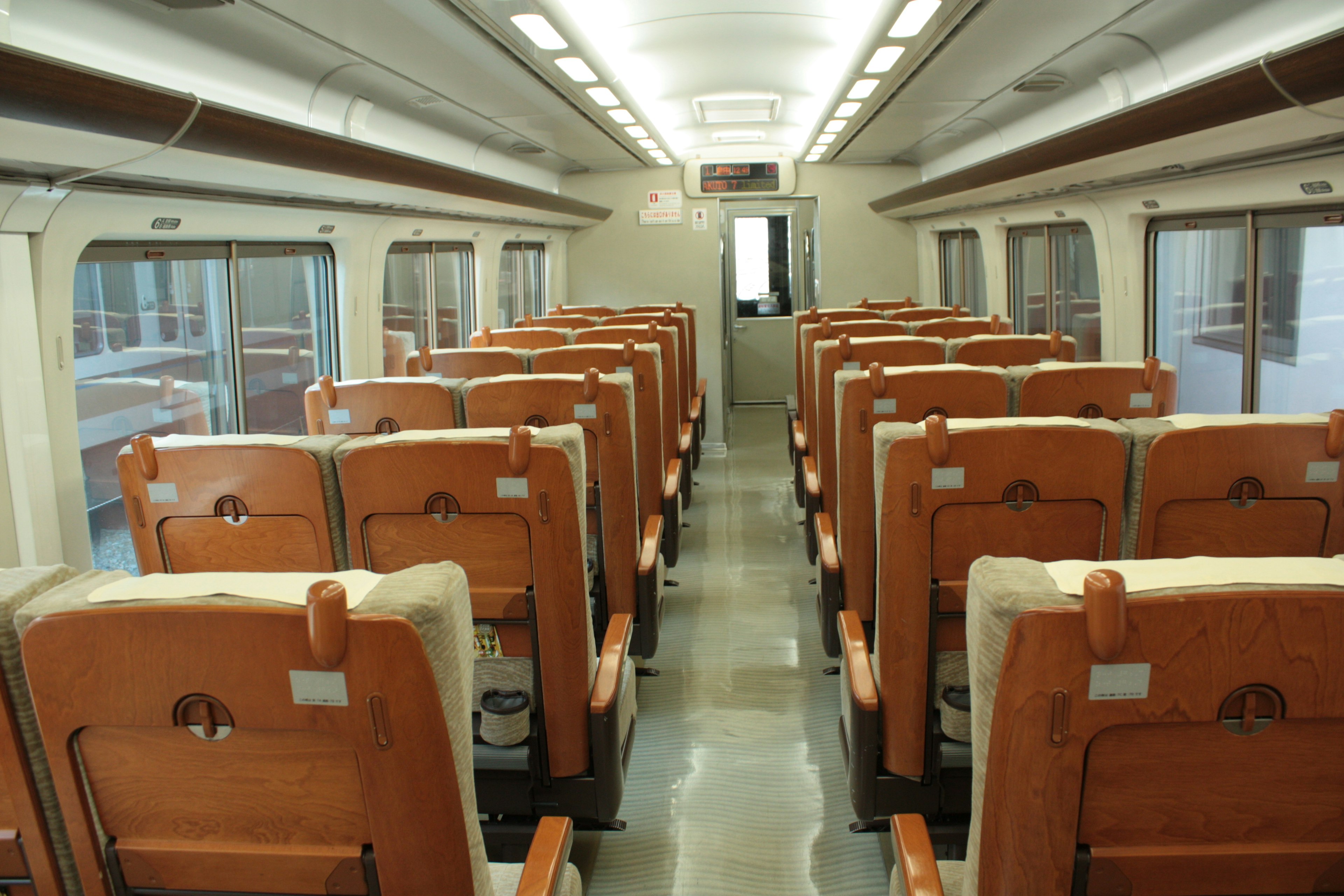 Interior of a train carriage featuring rows of leather seats