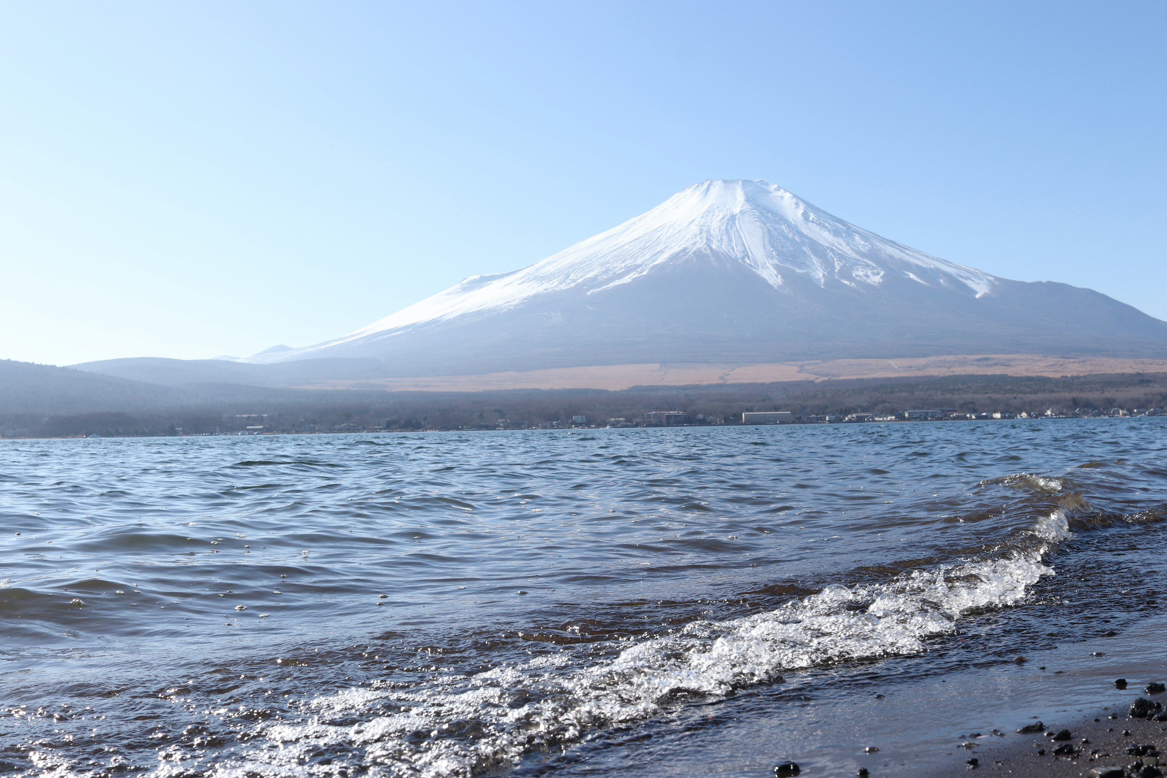 Scenic view of snow-capped Mount Fuji with a calm lake in the foreground