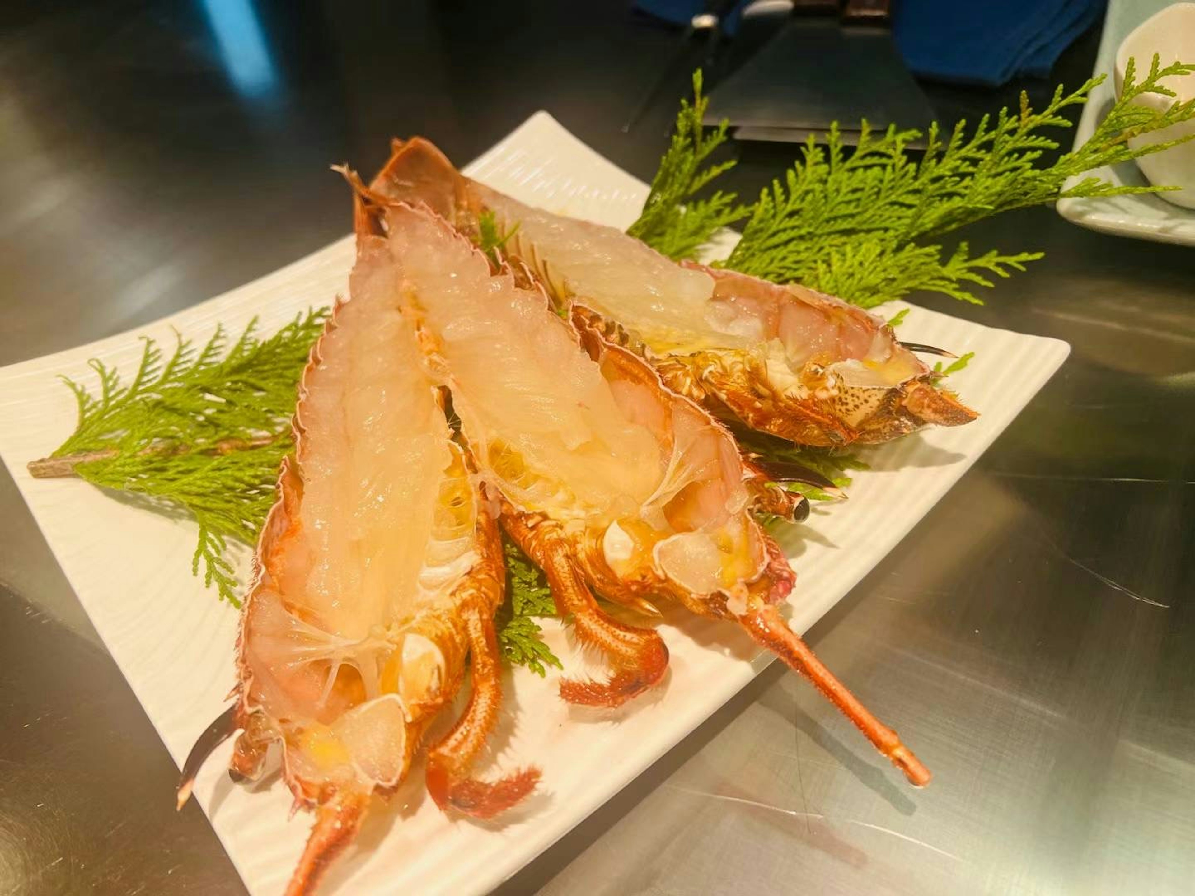 Platte mit lebhaftem Garnelen-Sashimi, garniert mit grünen Blättern