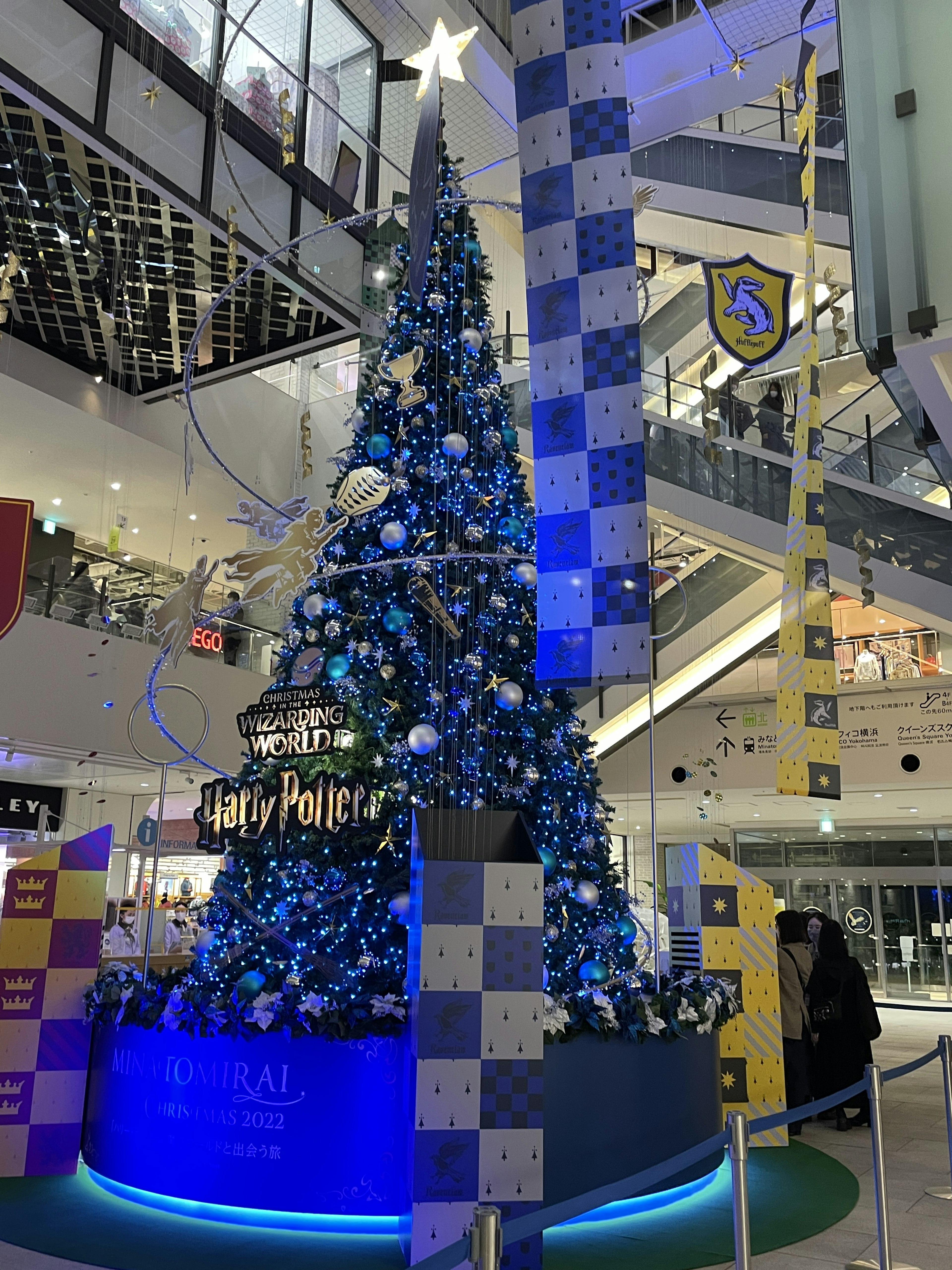 Un arbre de Noël décoré en bleu et blanc à l'intérieur d'un centre commercial