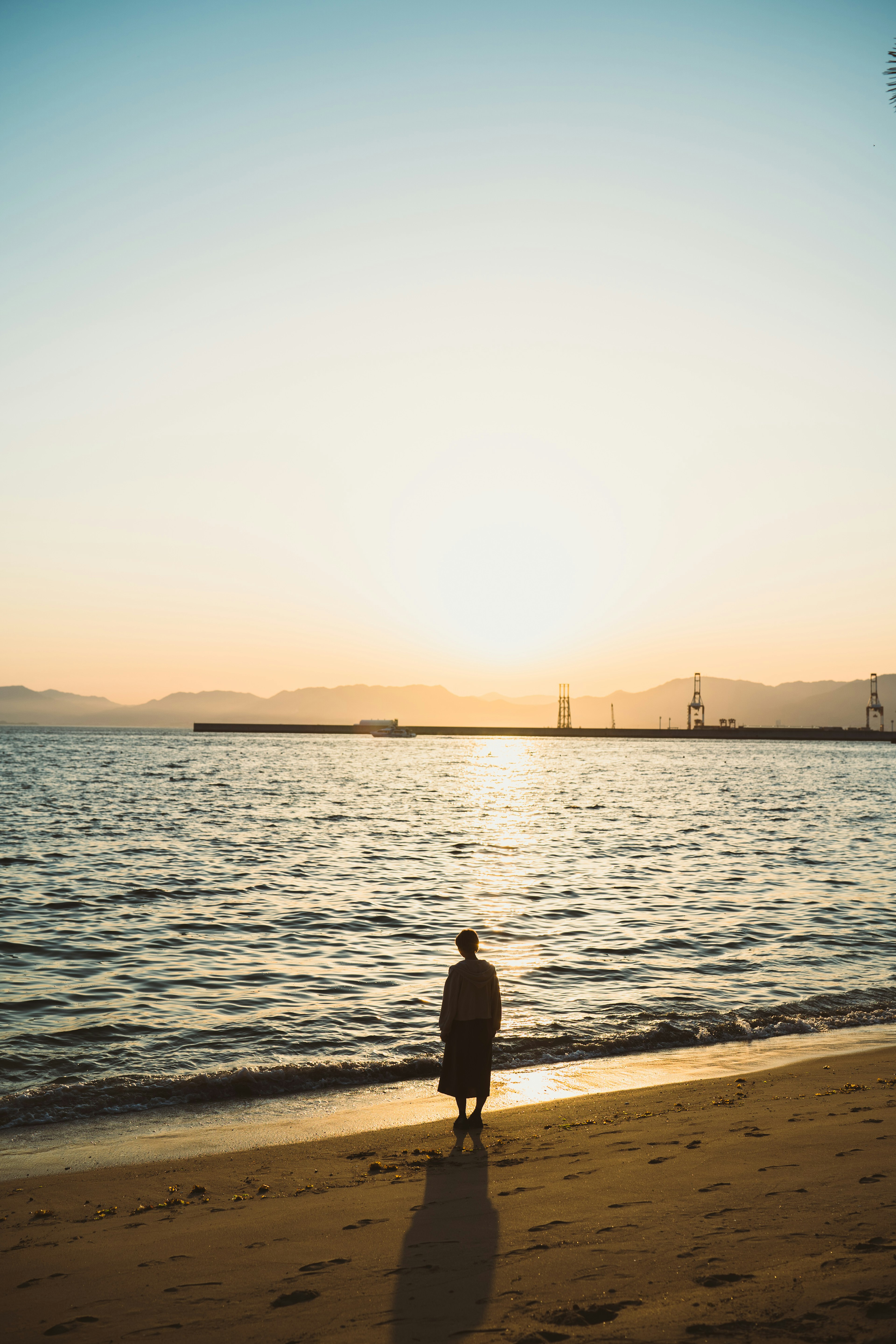 Silhouette of a person gazing at the sunset on the beach