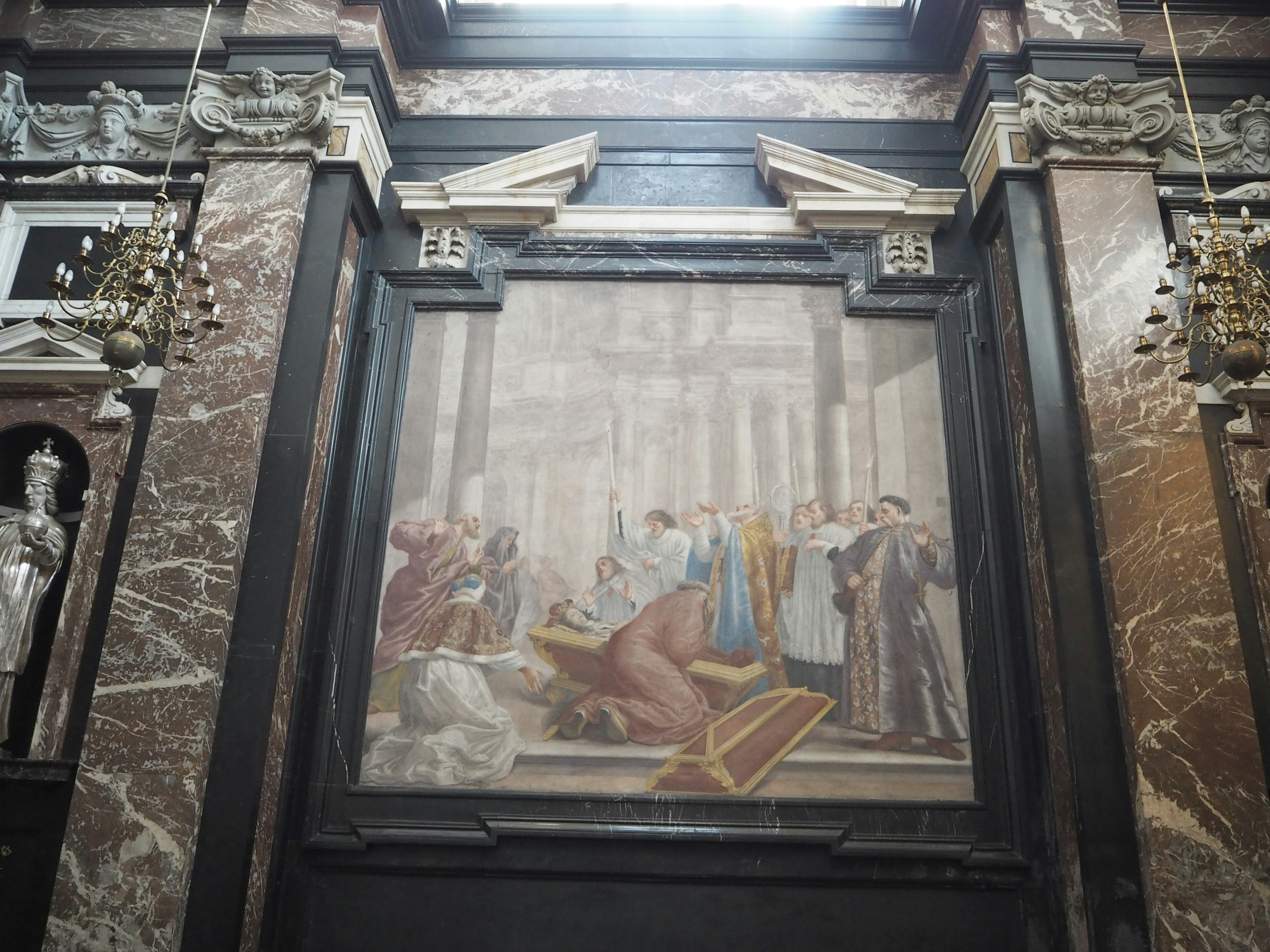 Innere einer Kirche mit einem religiösen Gemälde und kunstvollen Skulpturen