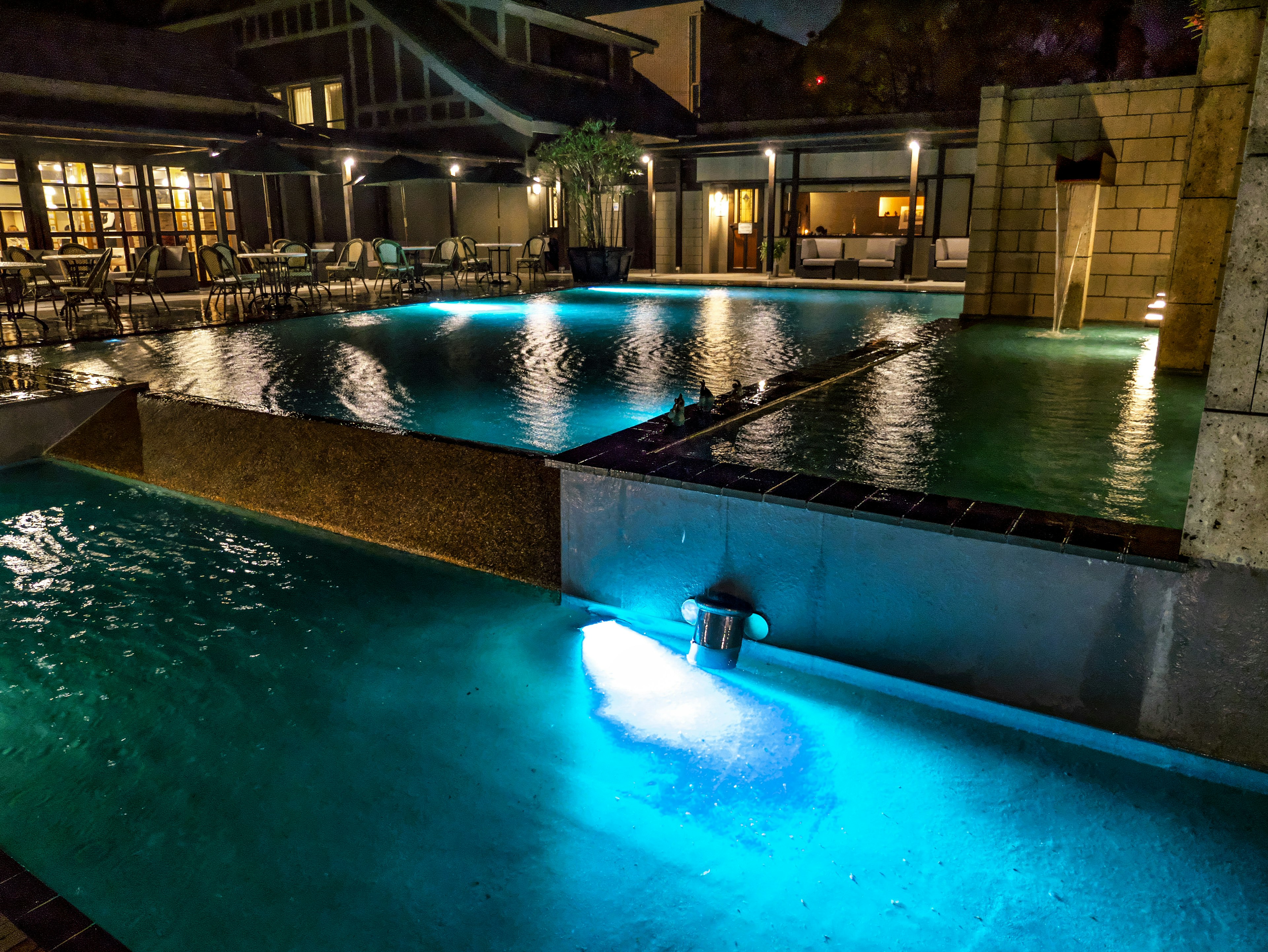 Vista notturna di una piscina di resort illuminata da luci blu