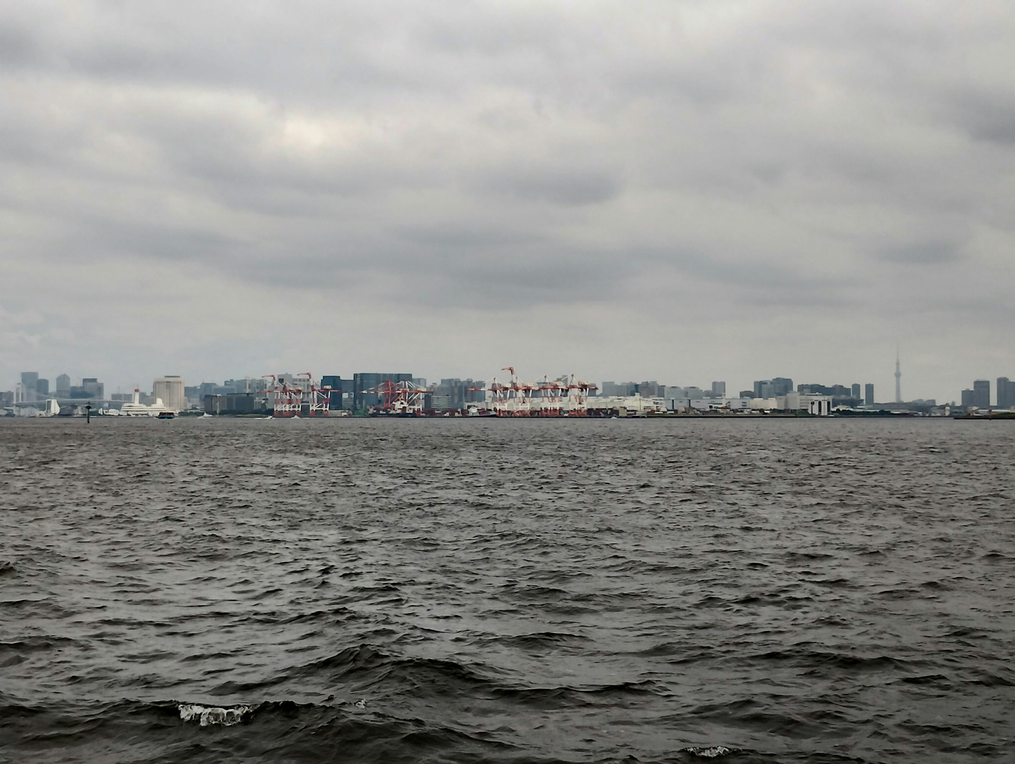 海と曇り空の背景に都市の景観が見える