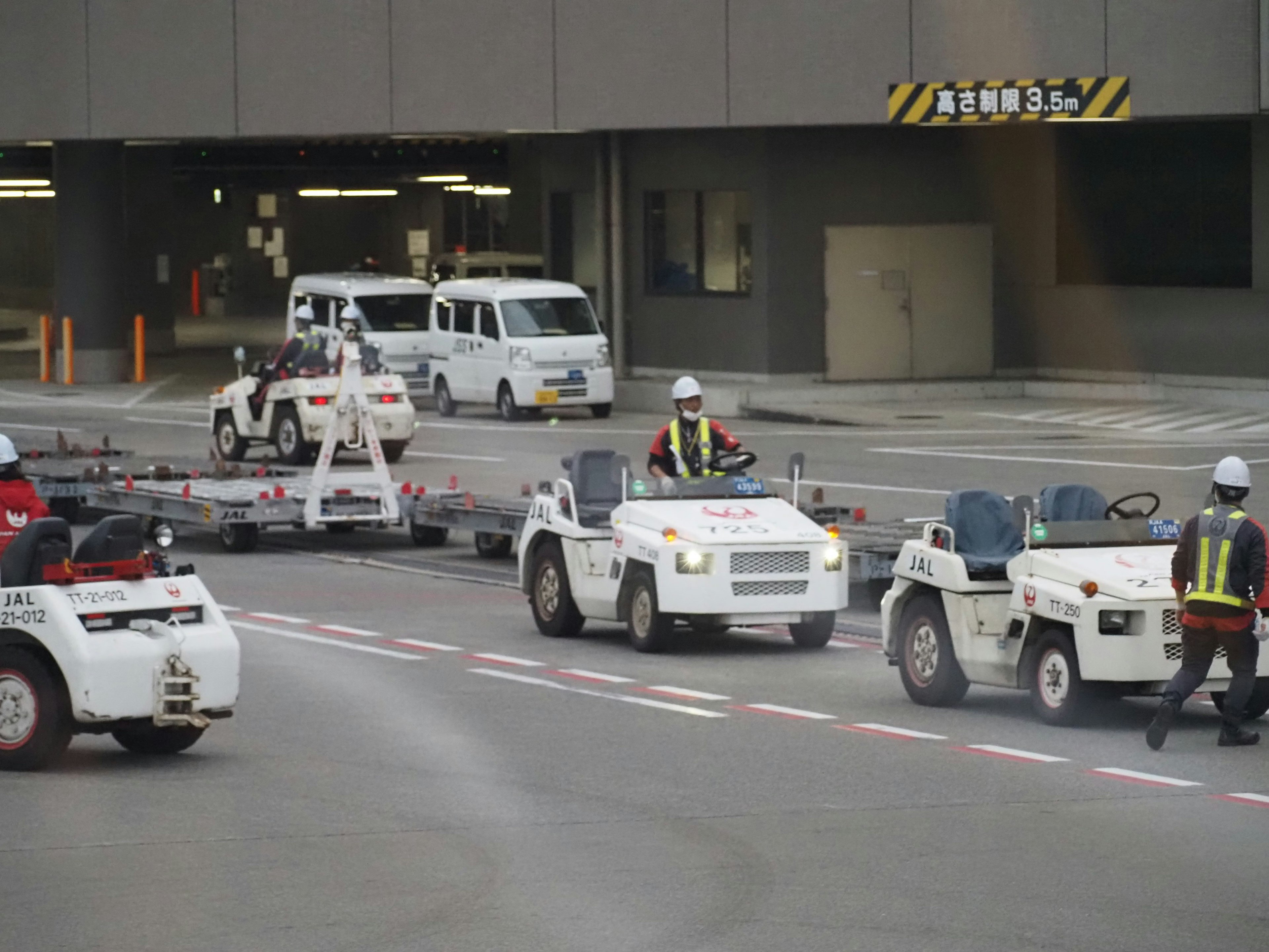 Airport scene with white service vehicles and workers