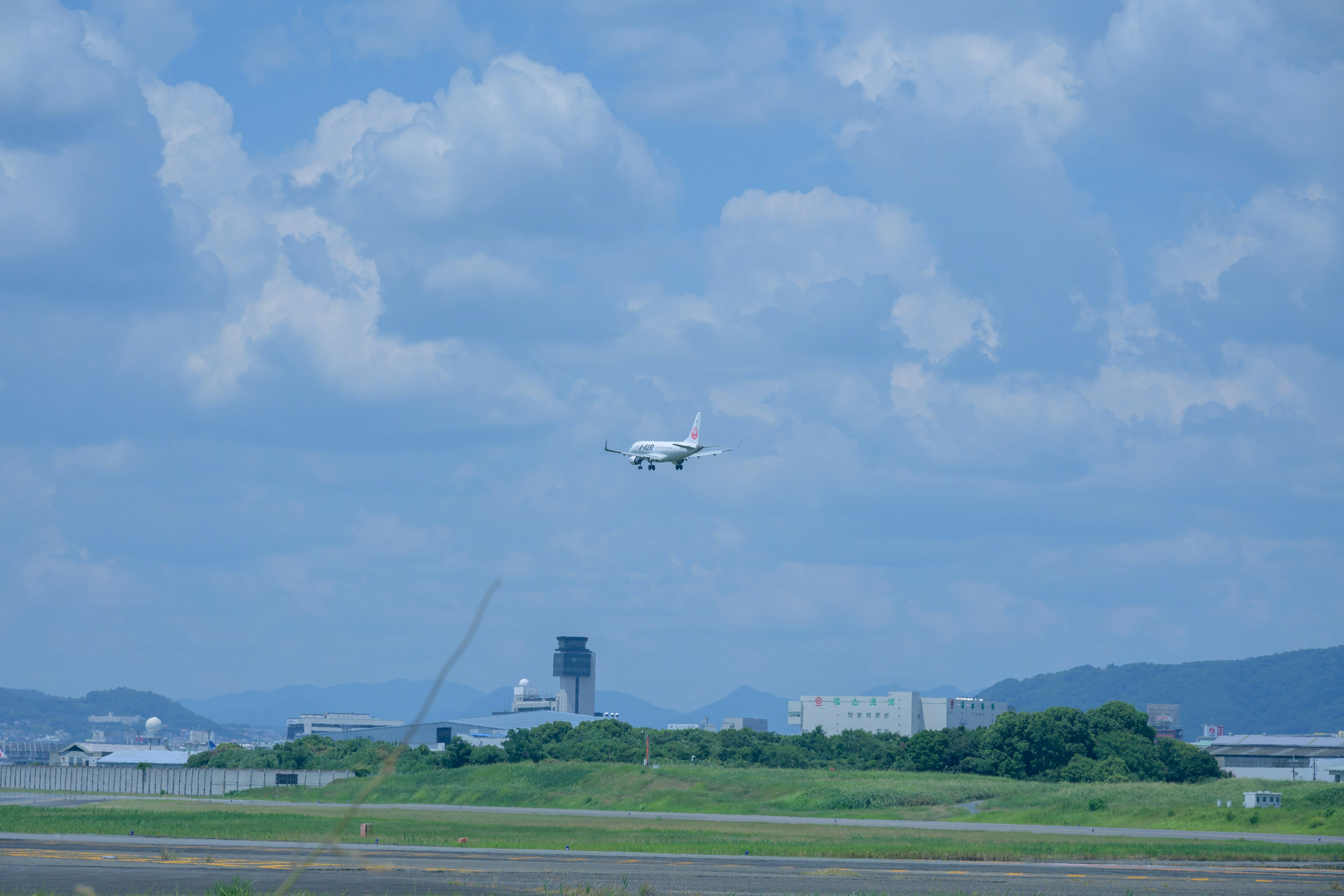 青空の下で着陸する白い飛行機と空港の風景