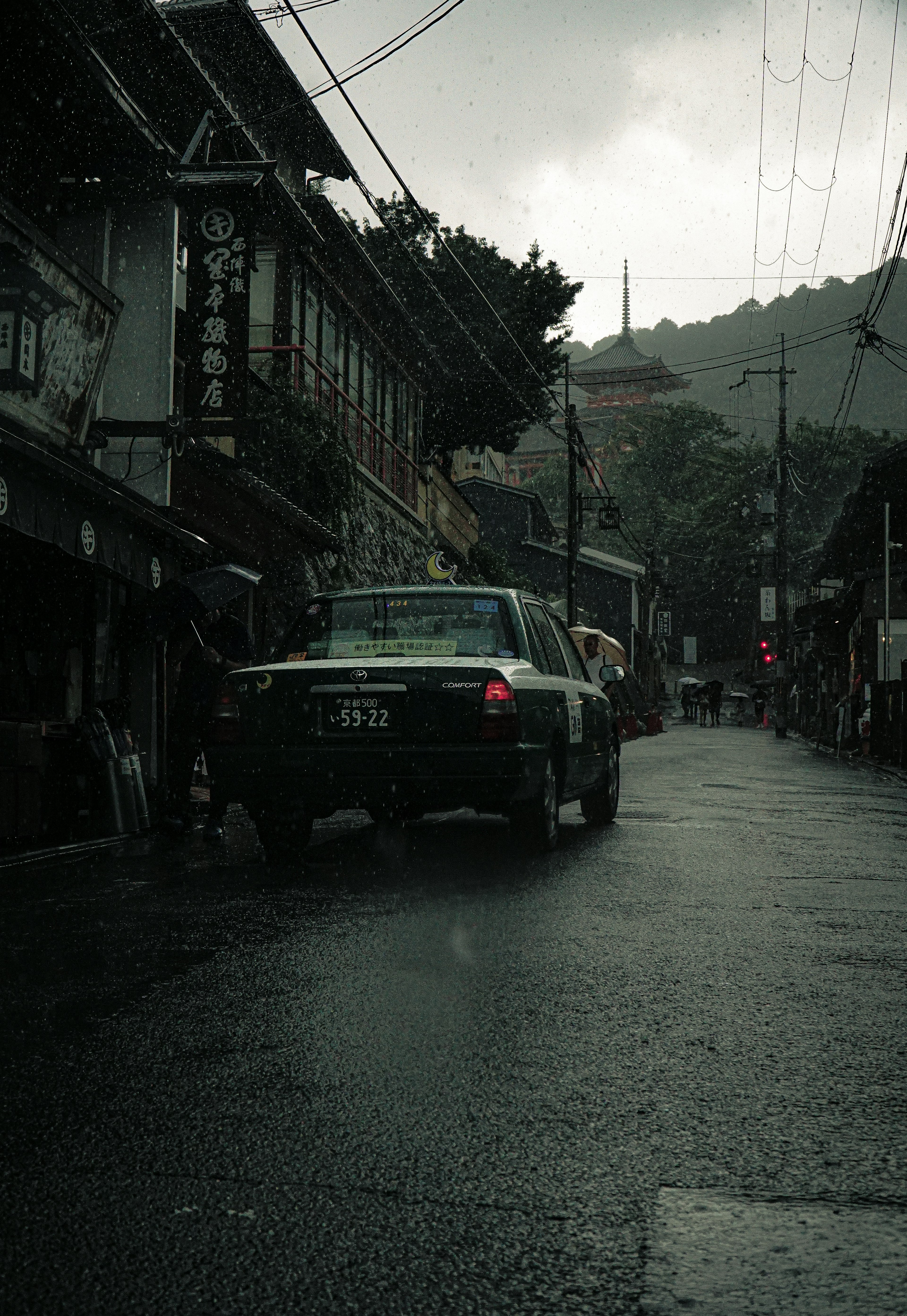 Scène de rue tranquille avec une voiture sous la pluie