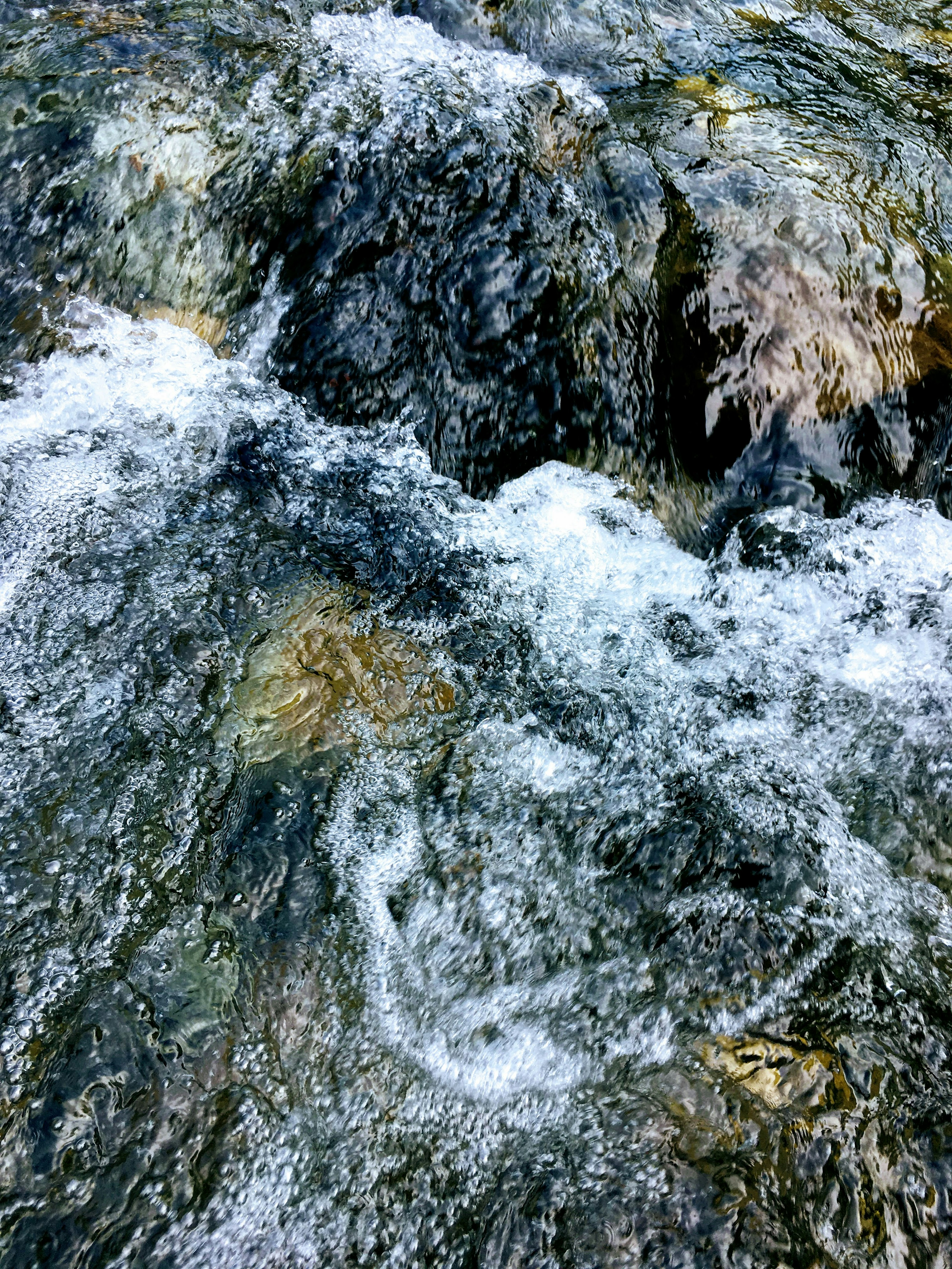 Agua clara fluyendo sobre rocas en un entorno natural