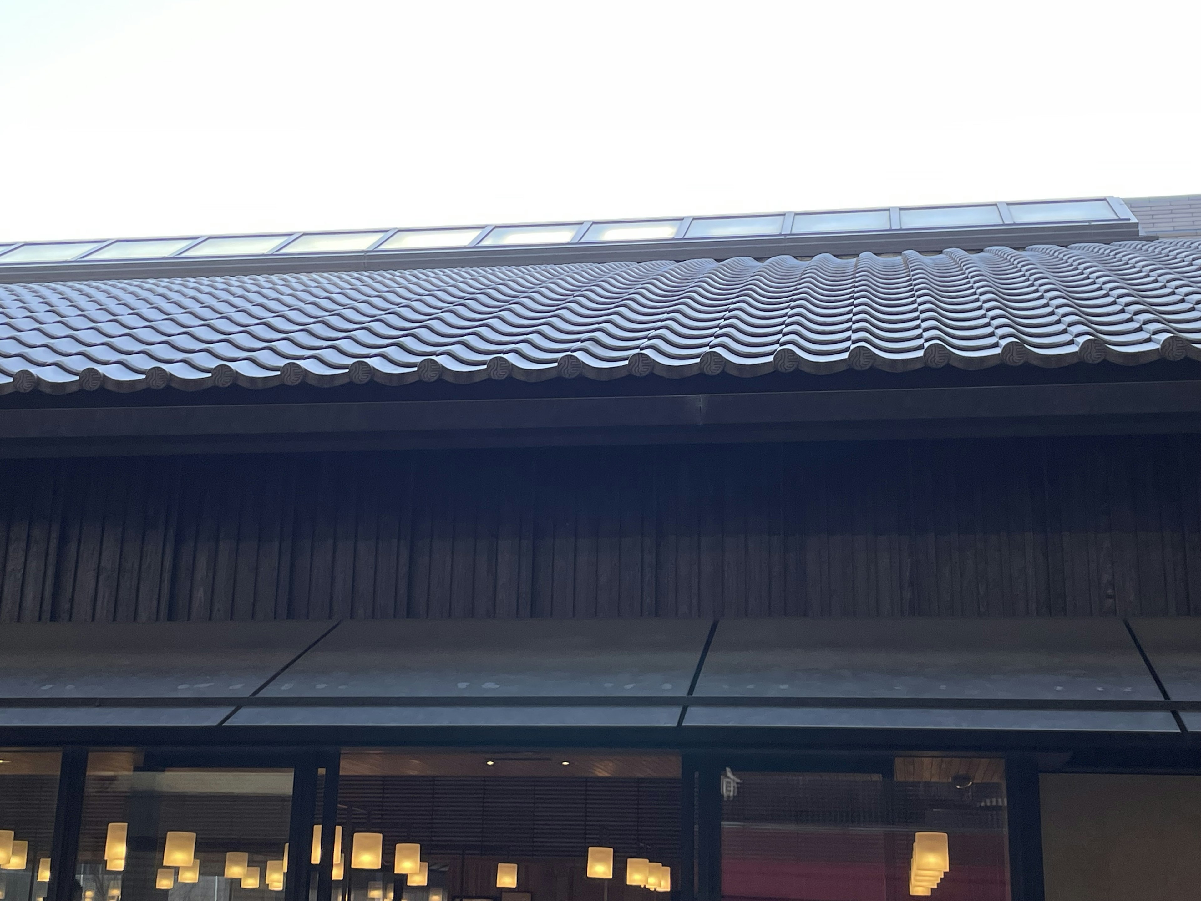 Traditional Japanese roof design with modern glass facade