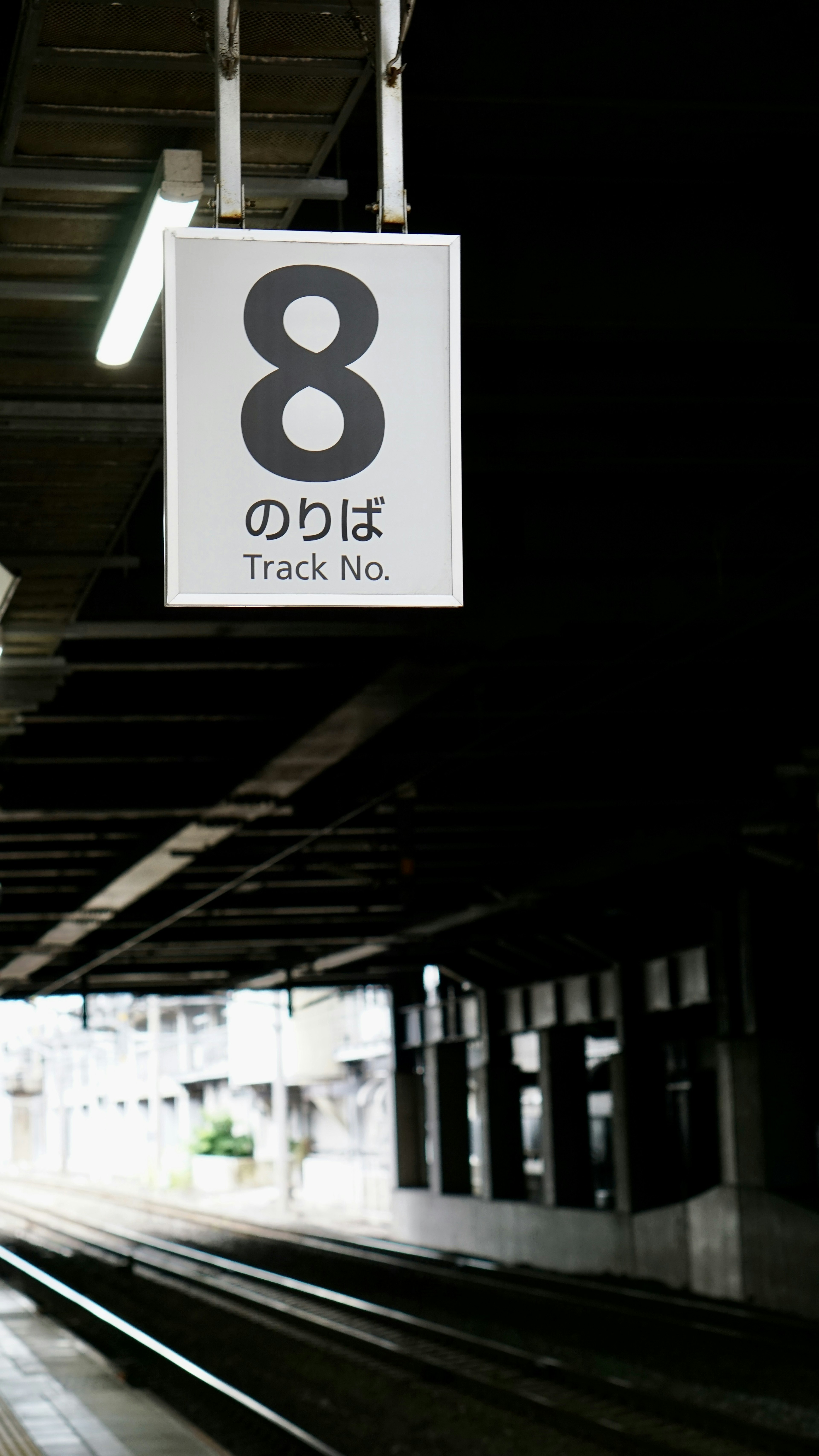 Señal de la plataforma 8 en una estación de tren con texto en japonés e inglés