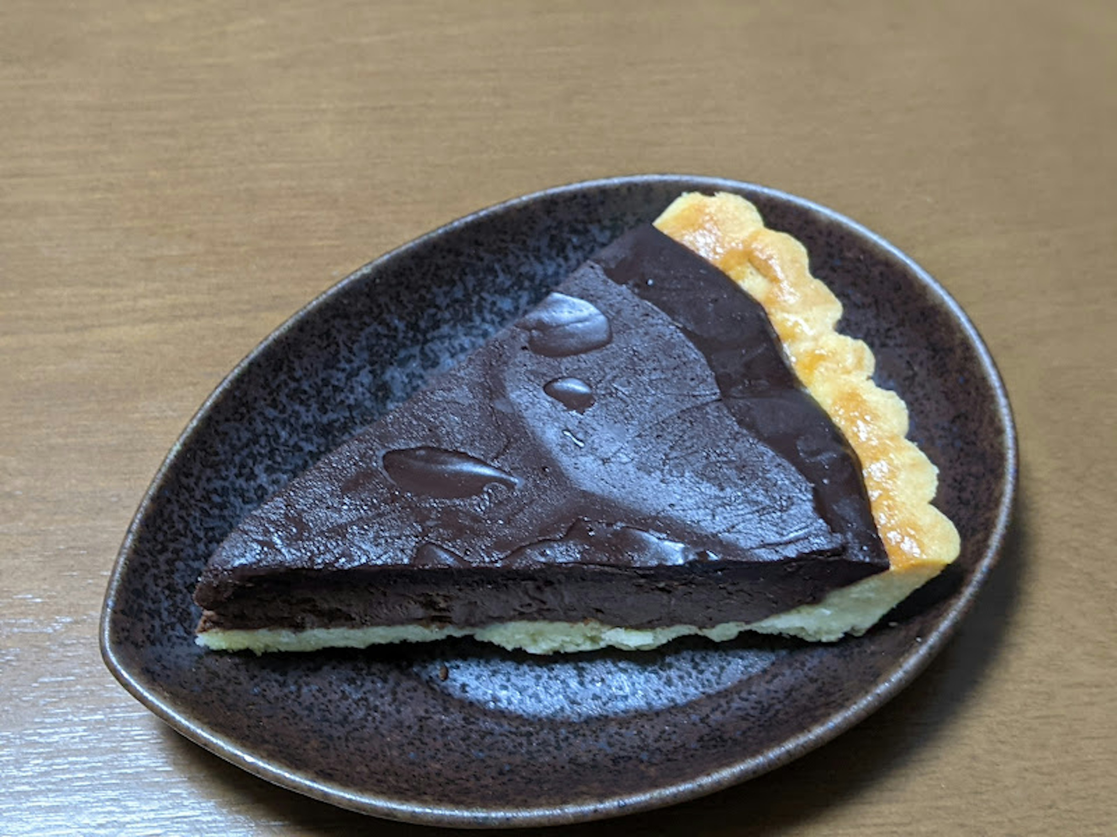 Slice of chocolate cake on a brown plate