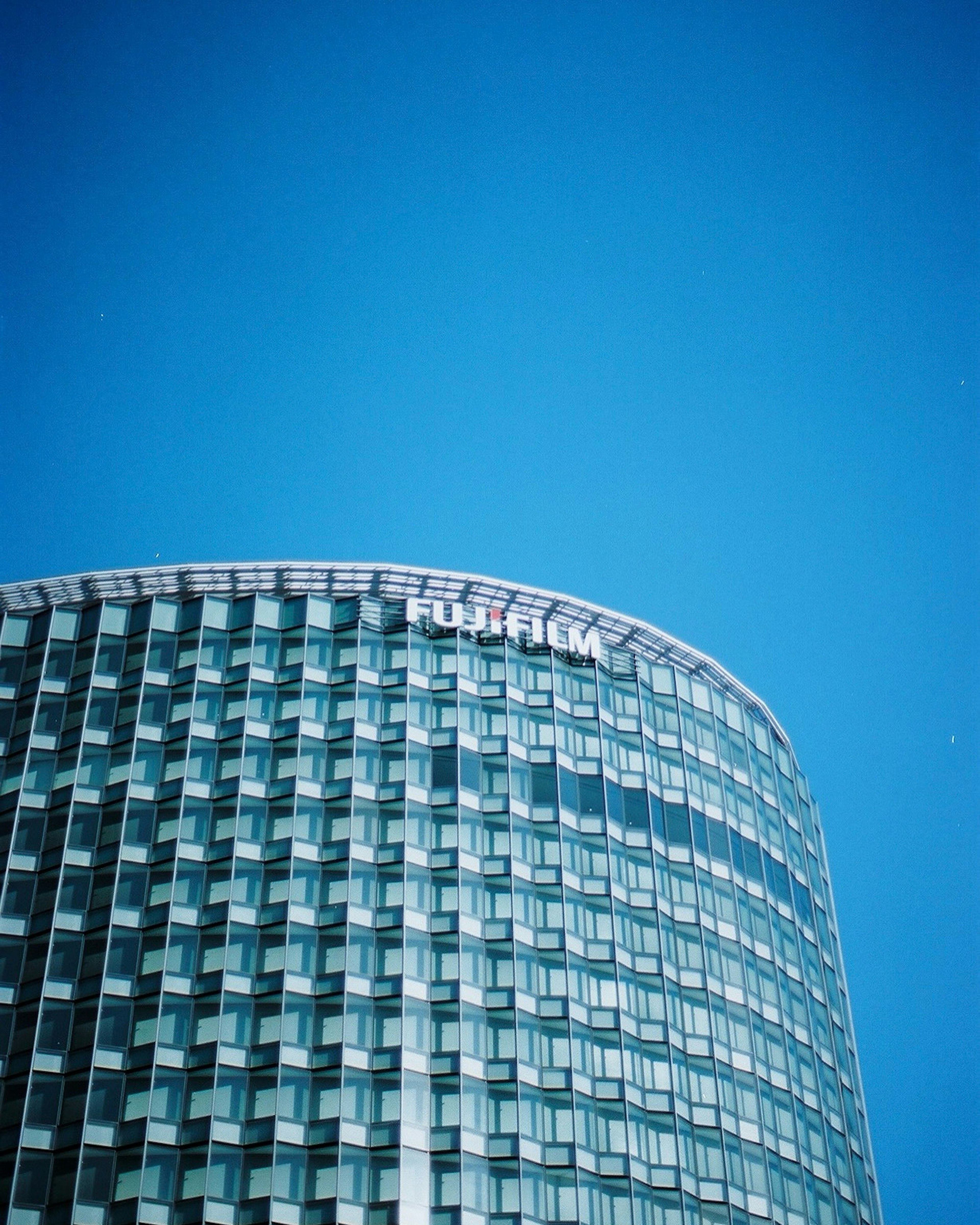 Foto eines modernen Glasgebäudes unter einem klaren blauen Himmel