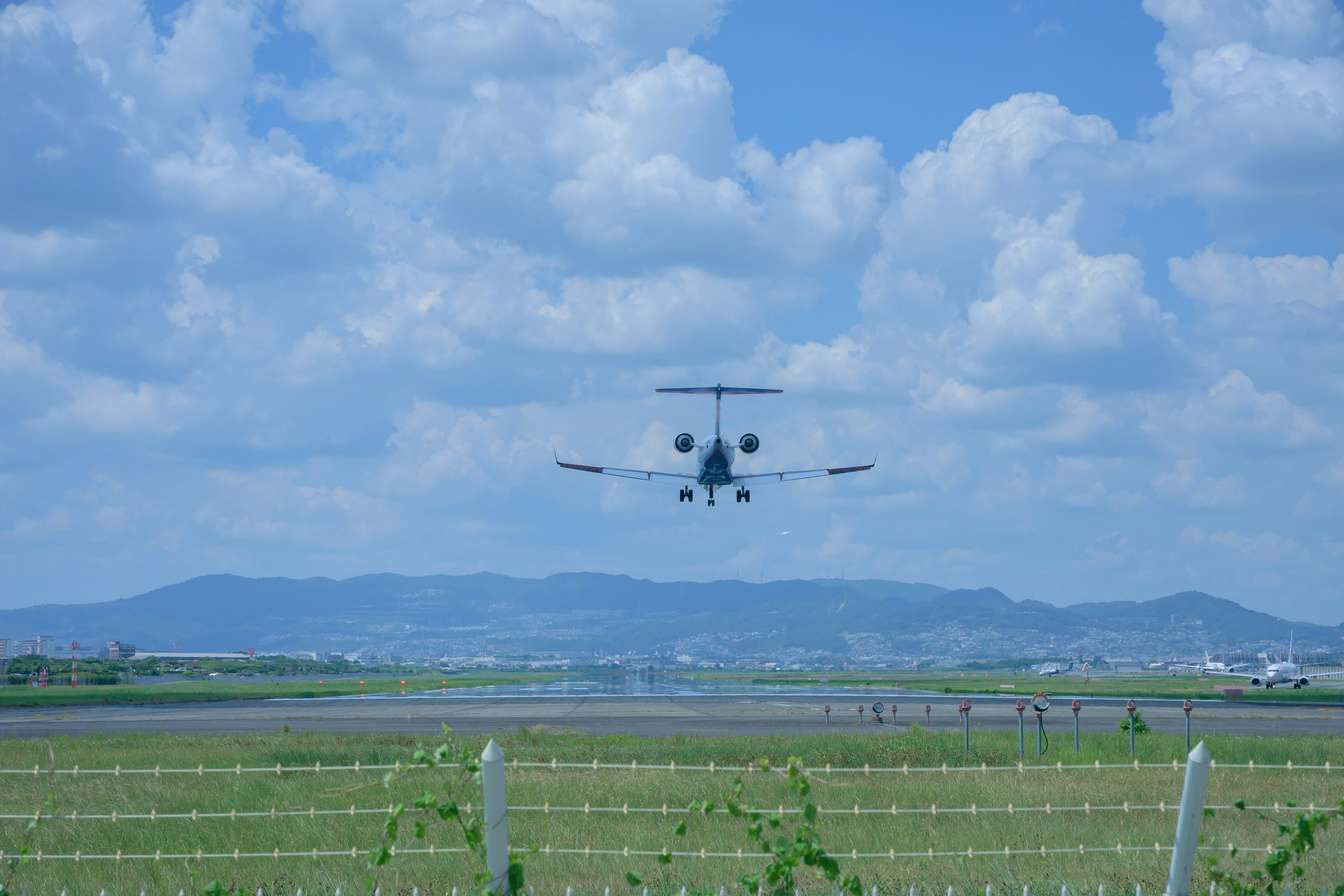 Petit avion atterrissant sous un ciel bleu avec de belles montagnes en arrière-plan