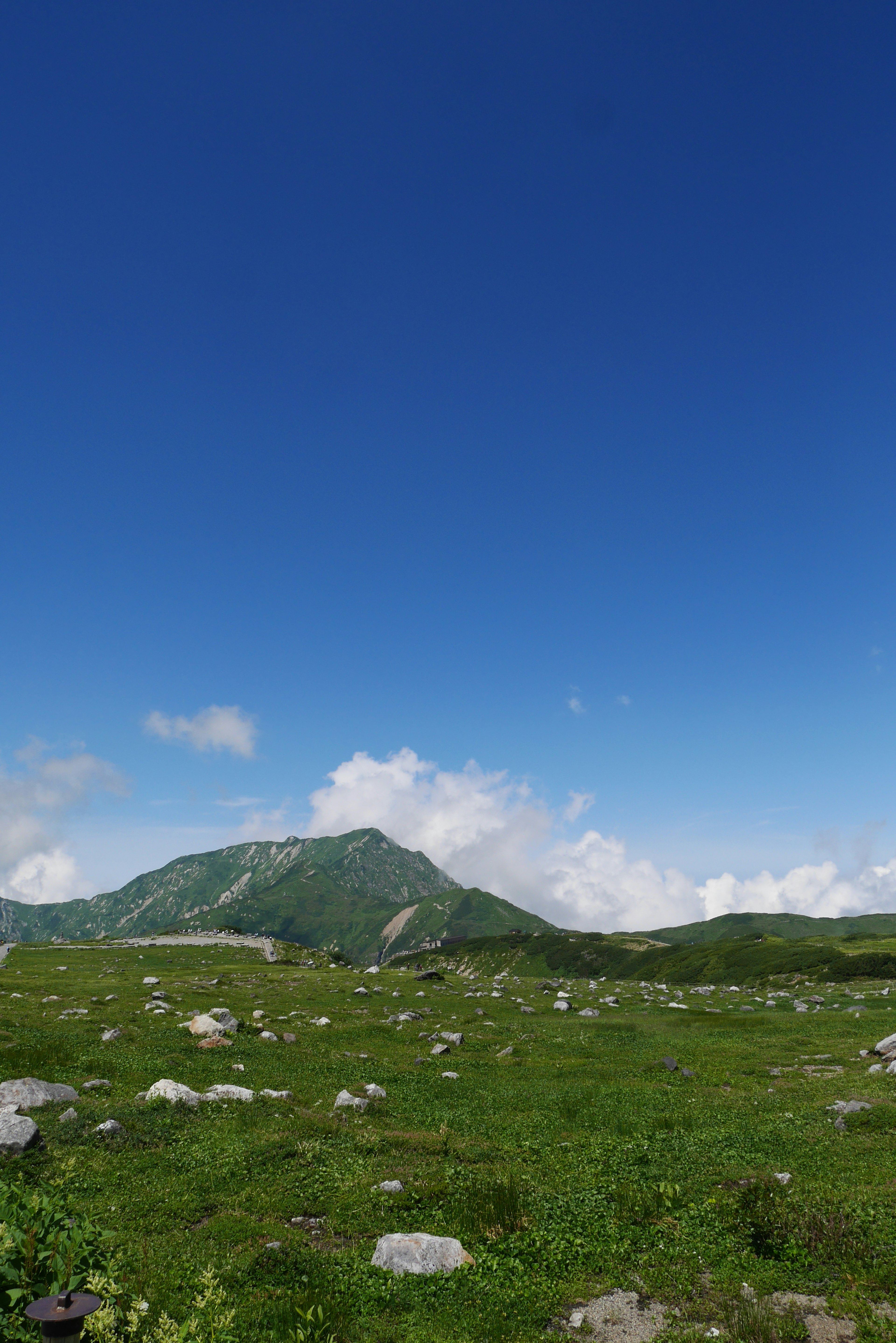 Paysage de montagne entouré d'herbe verte et d'un ciel bleu