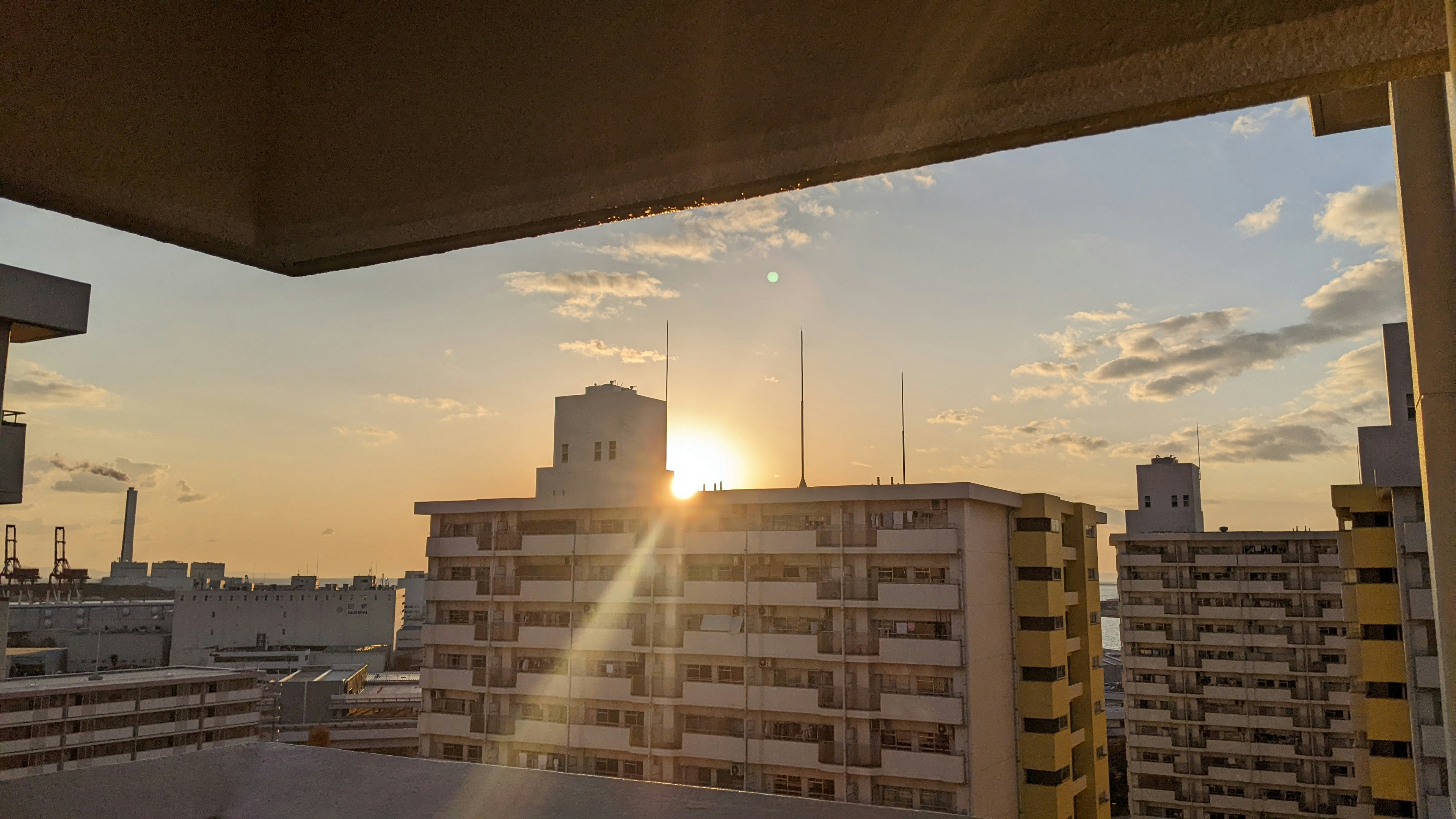 Cityscape with sunset visible between buildings