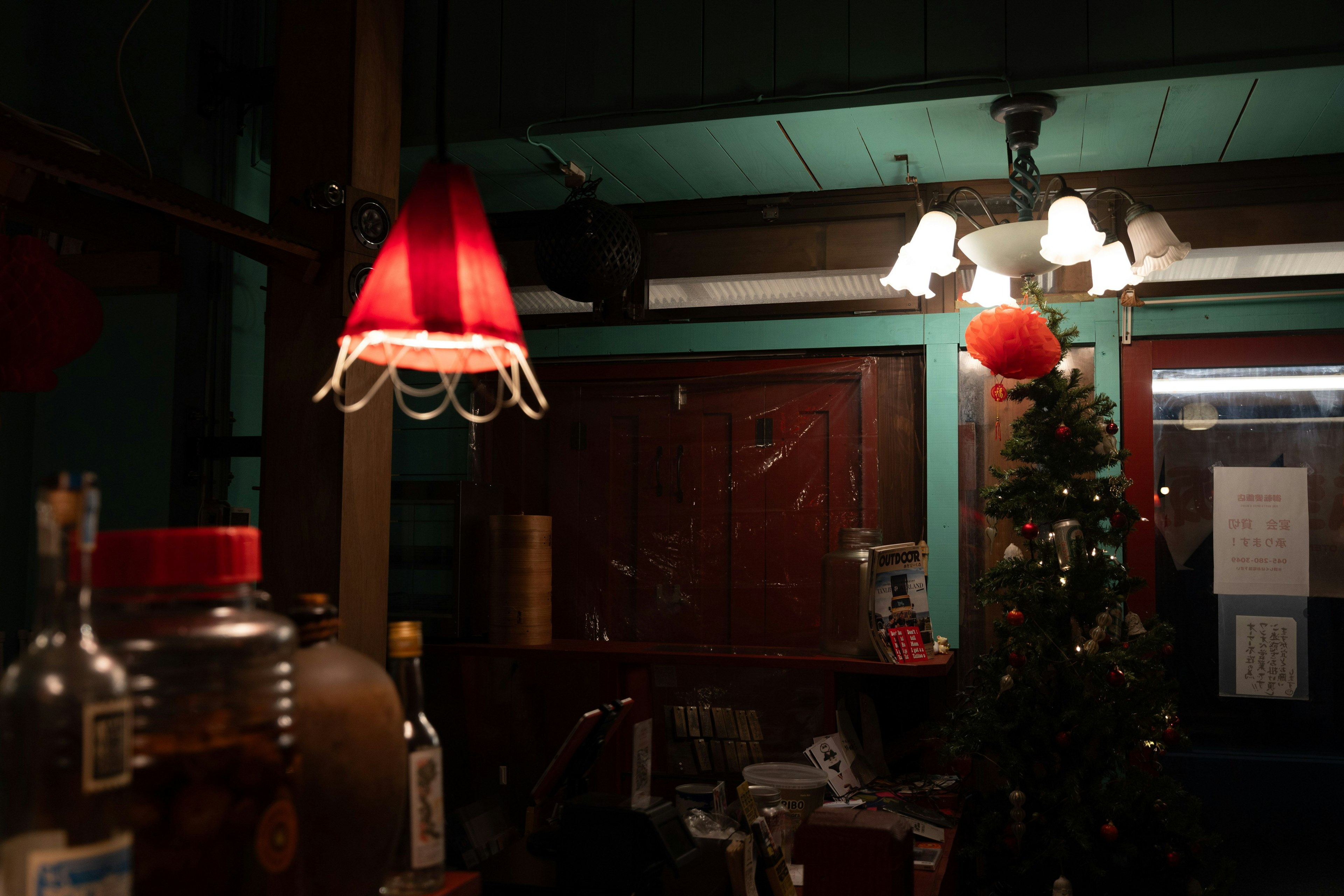 Escena interior acogedora con una lámpara roja y un árbol de Navidad