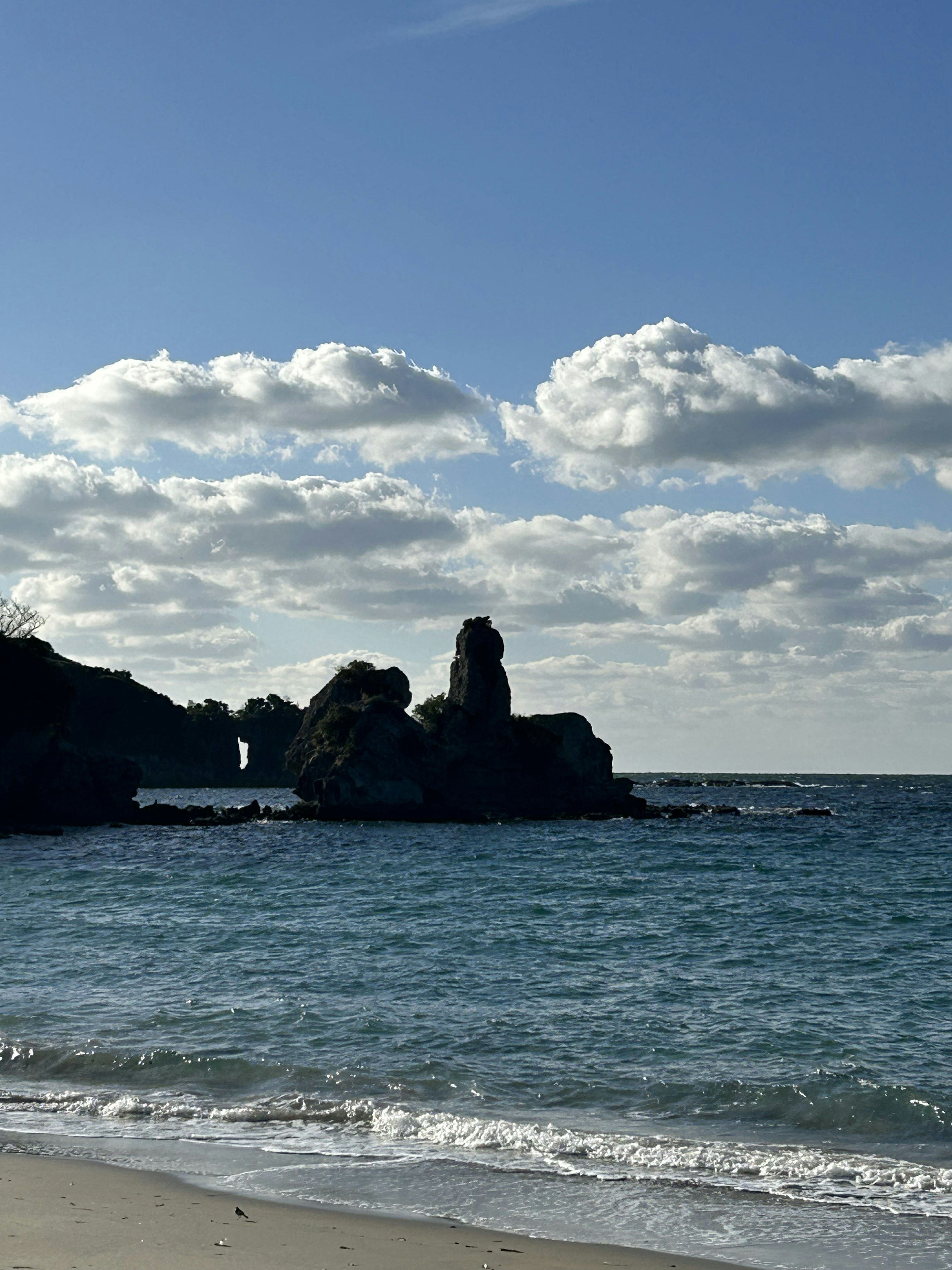 Vista escénica de una costa rocosa con océano azul y playa de arena