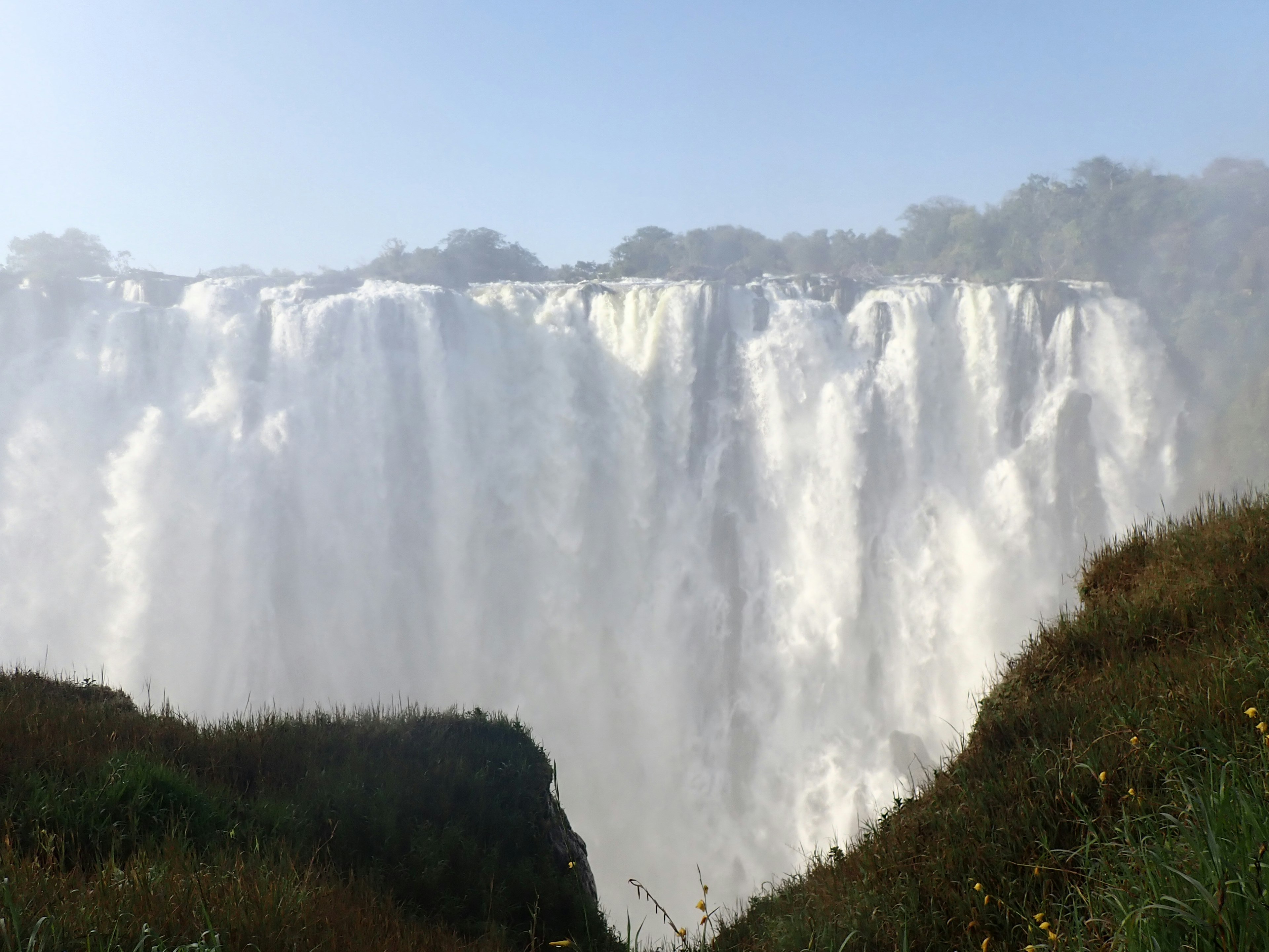 Vista majestuosa de las cataratas del Iguazú con agua cayendo bajo un cielo azul