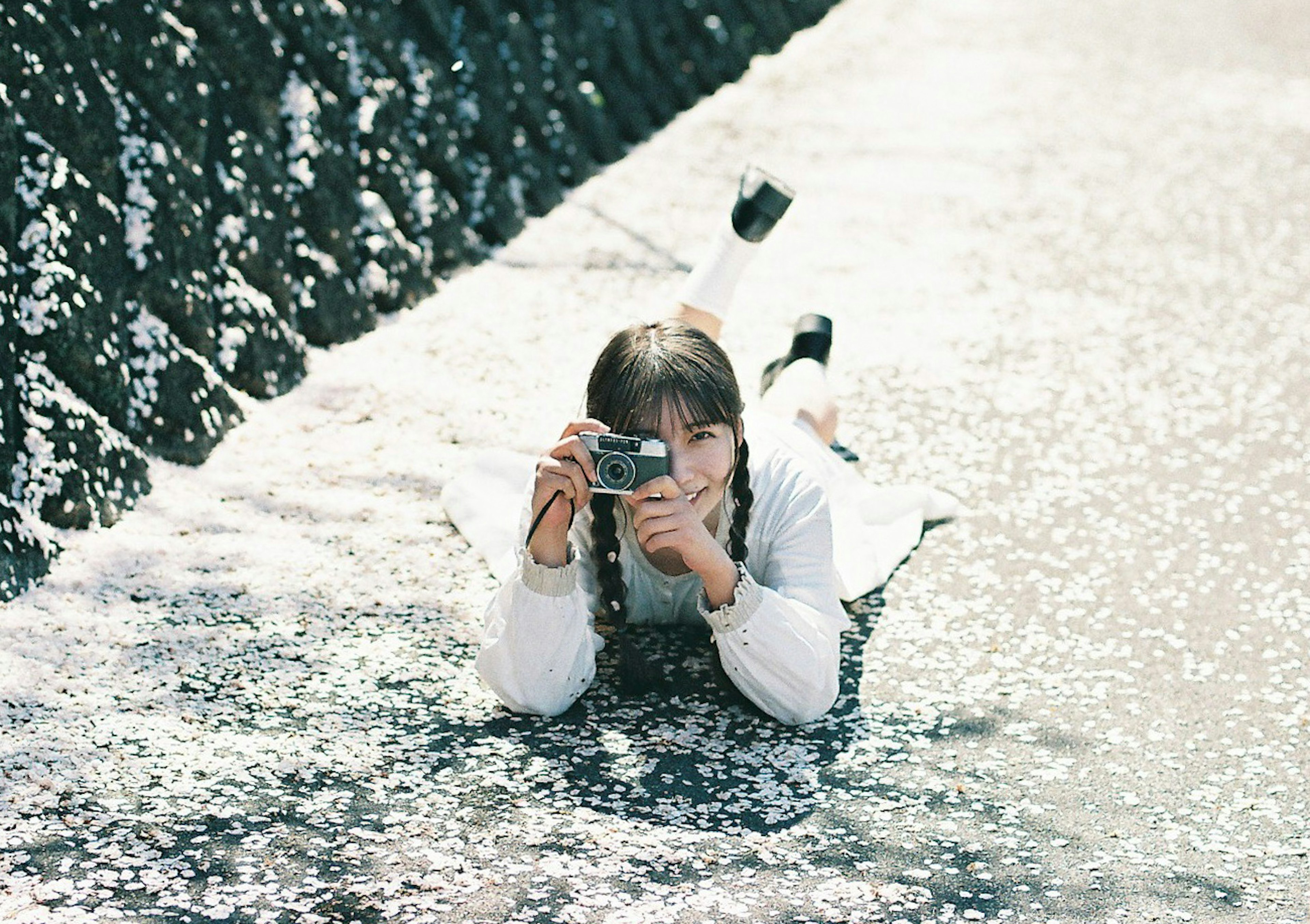 Girl lying in water holding a camera