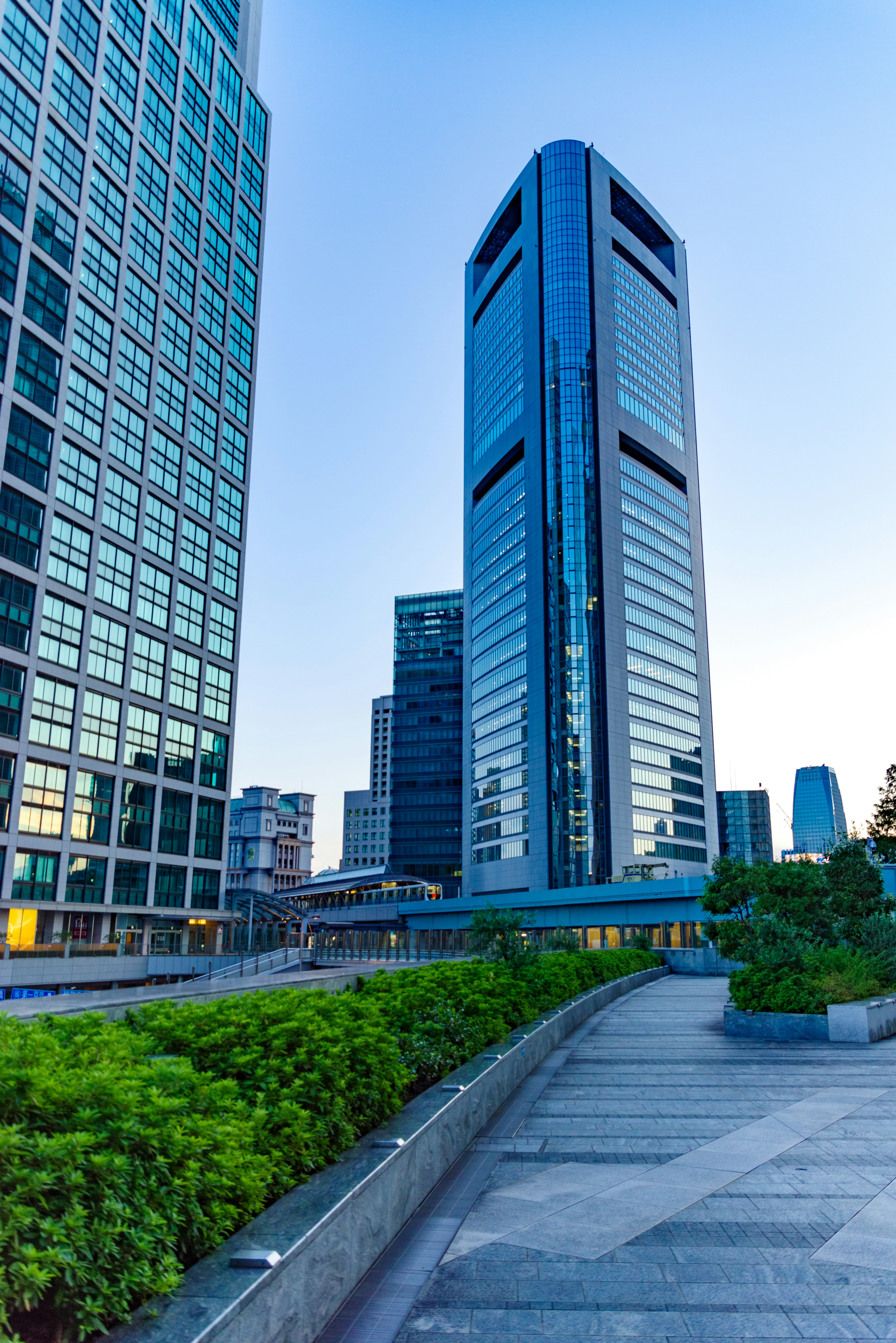 Urban landscape featuring a tall skyscraper against a blue sky