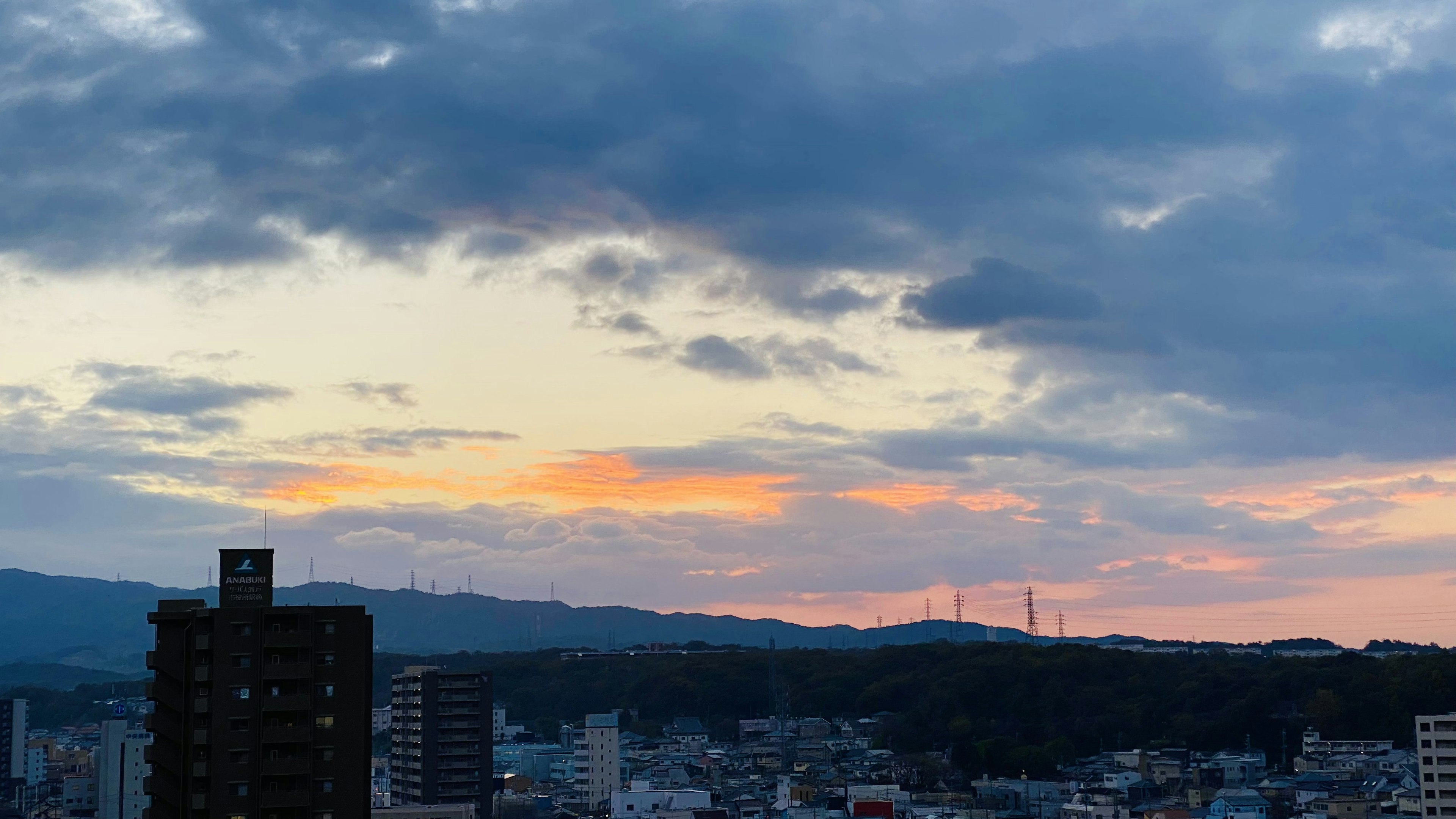 日落时的城市景观，五彩缤纷的天空和远处的山脉