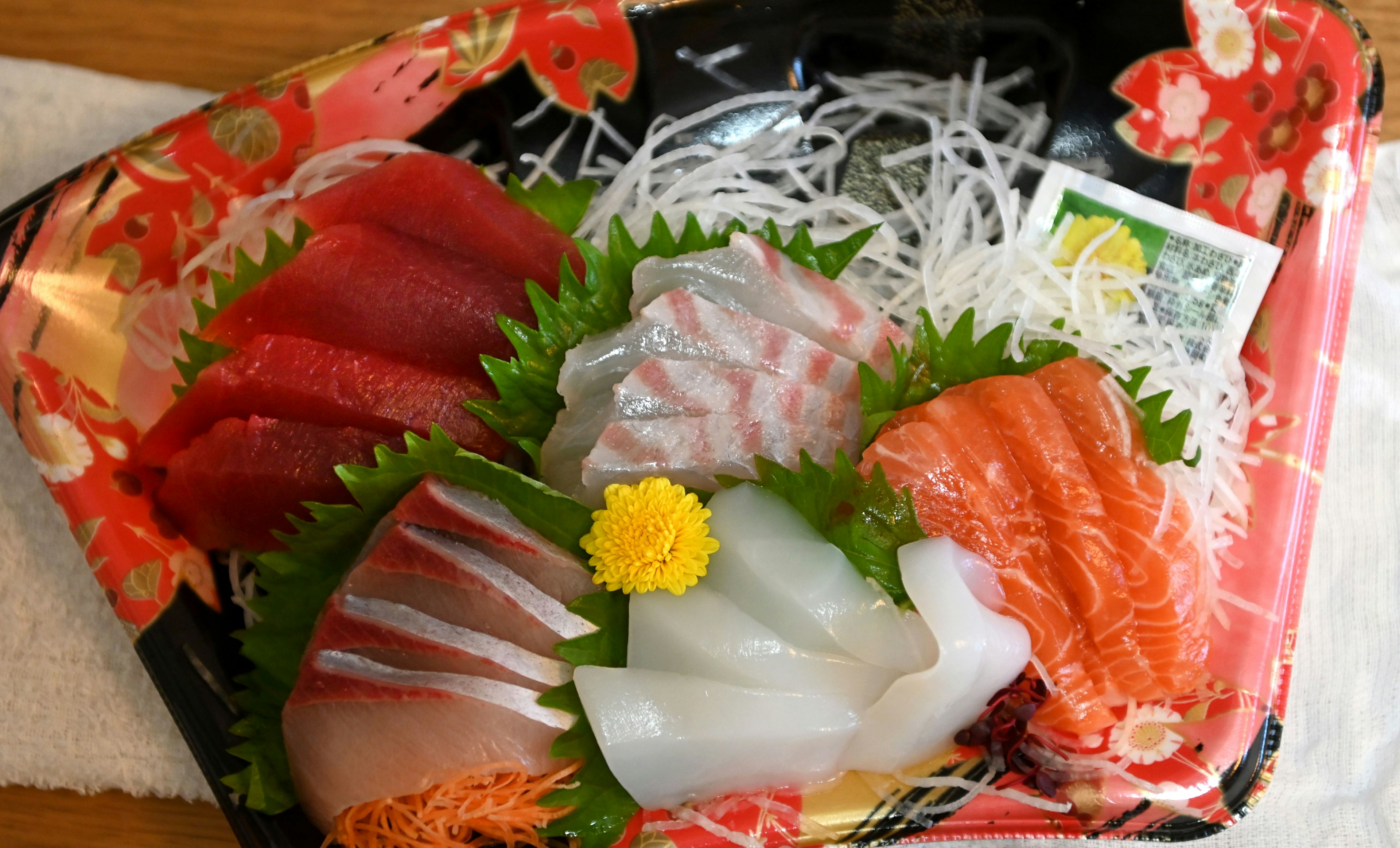 Đĩa sashimi tươi với cá đa dạng và củ cải trắng bào