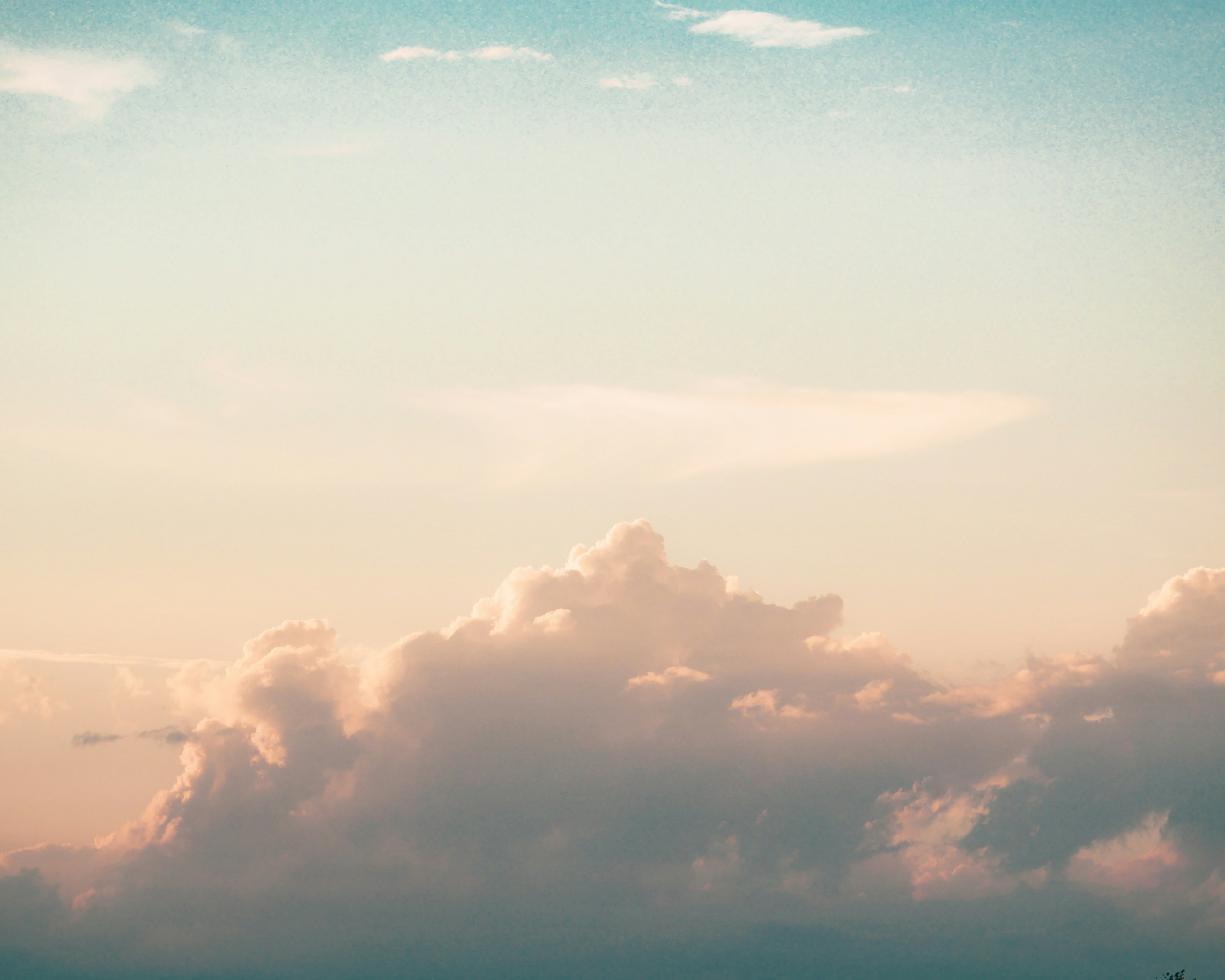 穏やかな青空に浮かぶ柔らかい雲と温かい色合いの夕暮れ