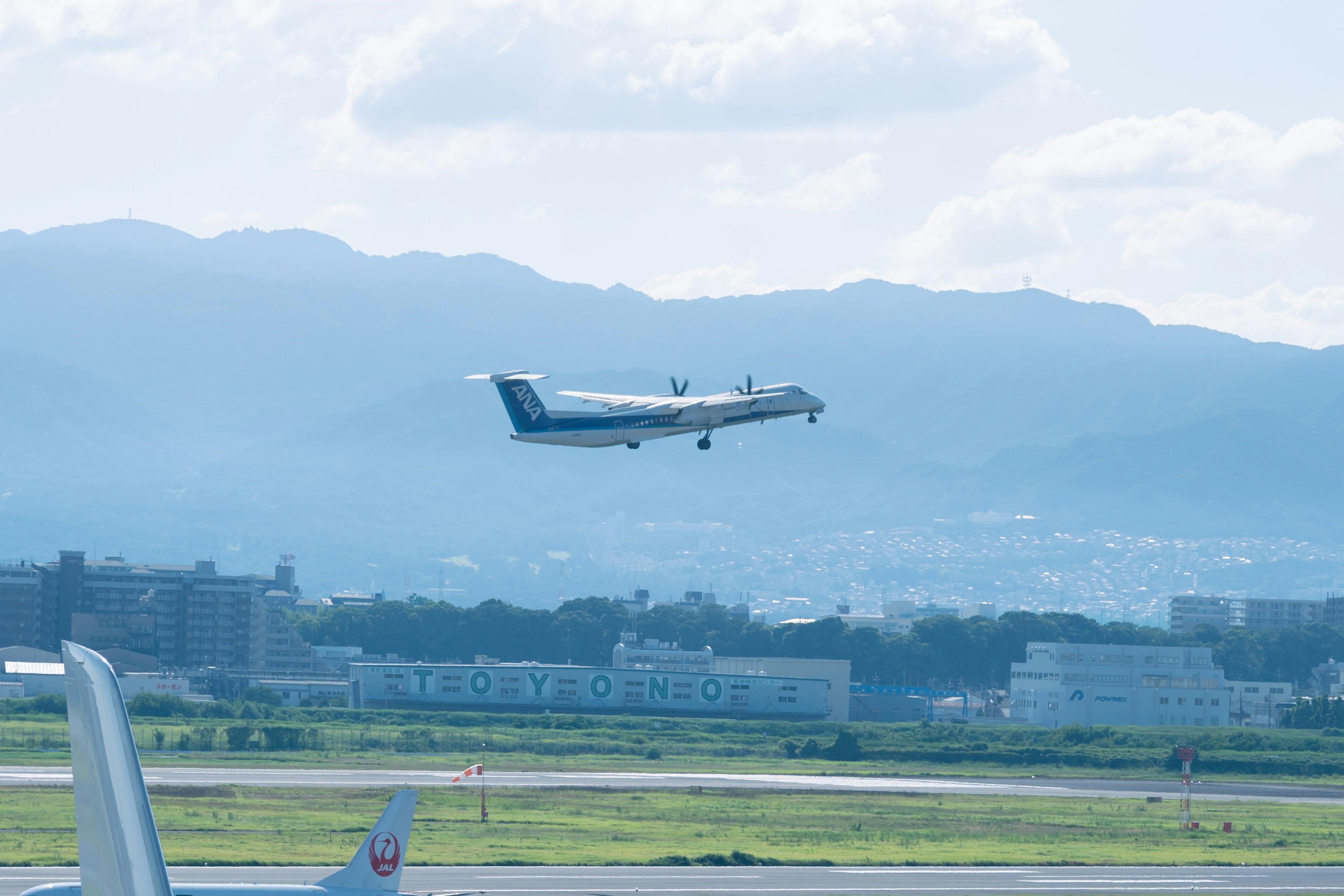 Pequeño avión despegando contra un cielo azul y montañas al fondo