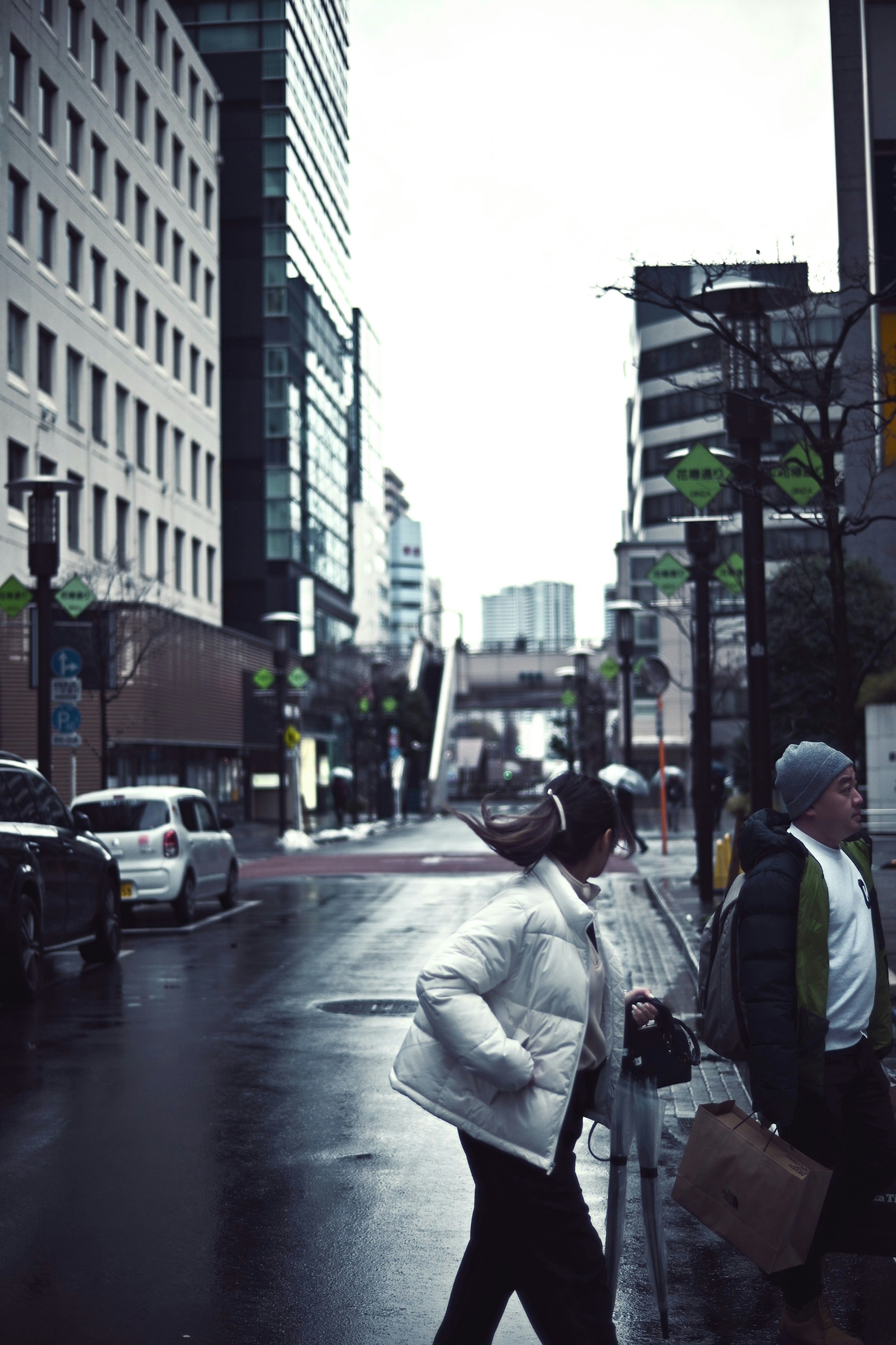 Urban scene with people walking in the rain and modern buildings