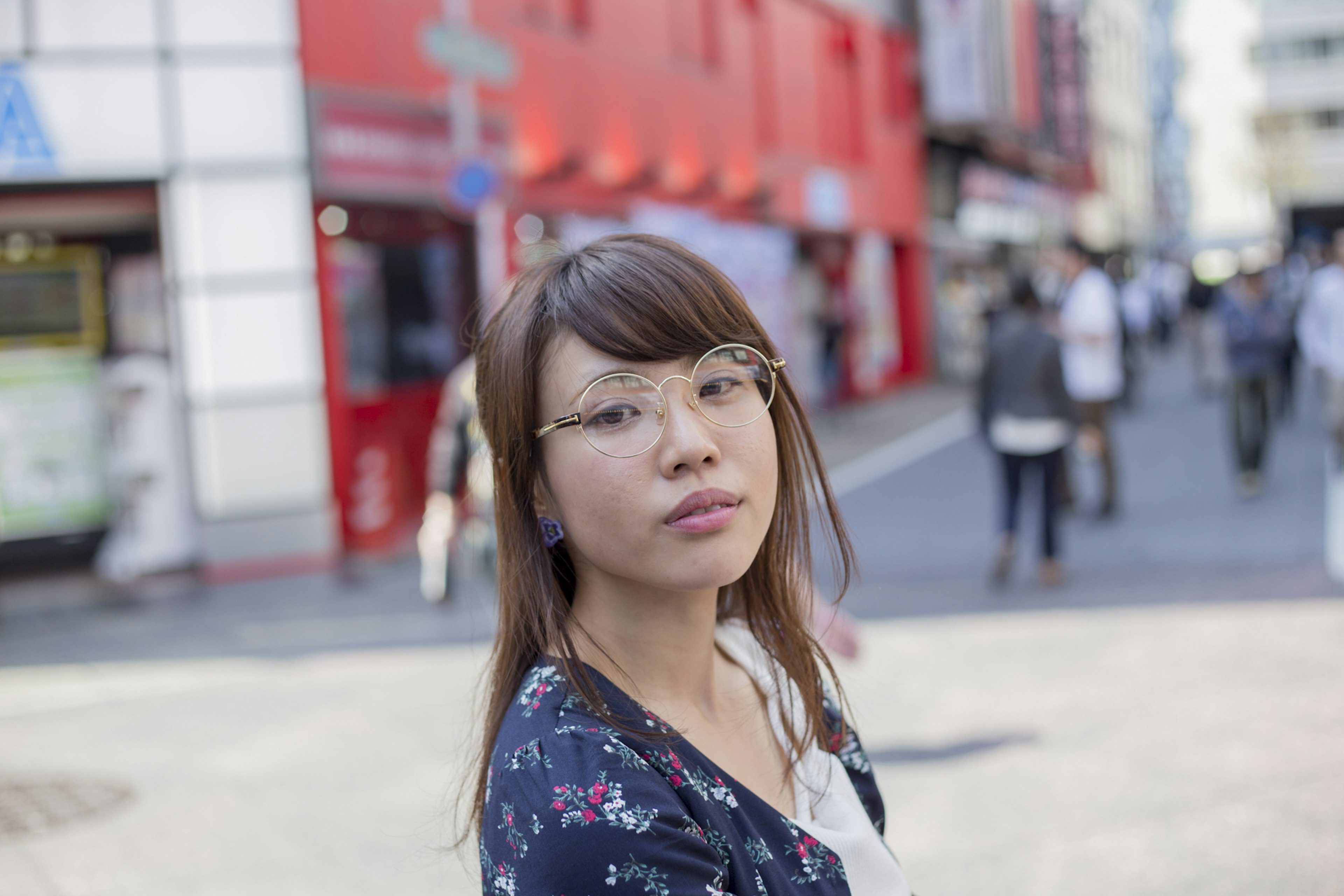 Retrato de una mujer mirando a la cámara en una calle con fondo rojo