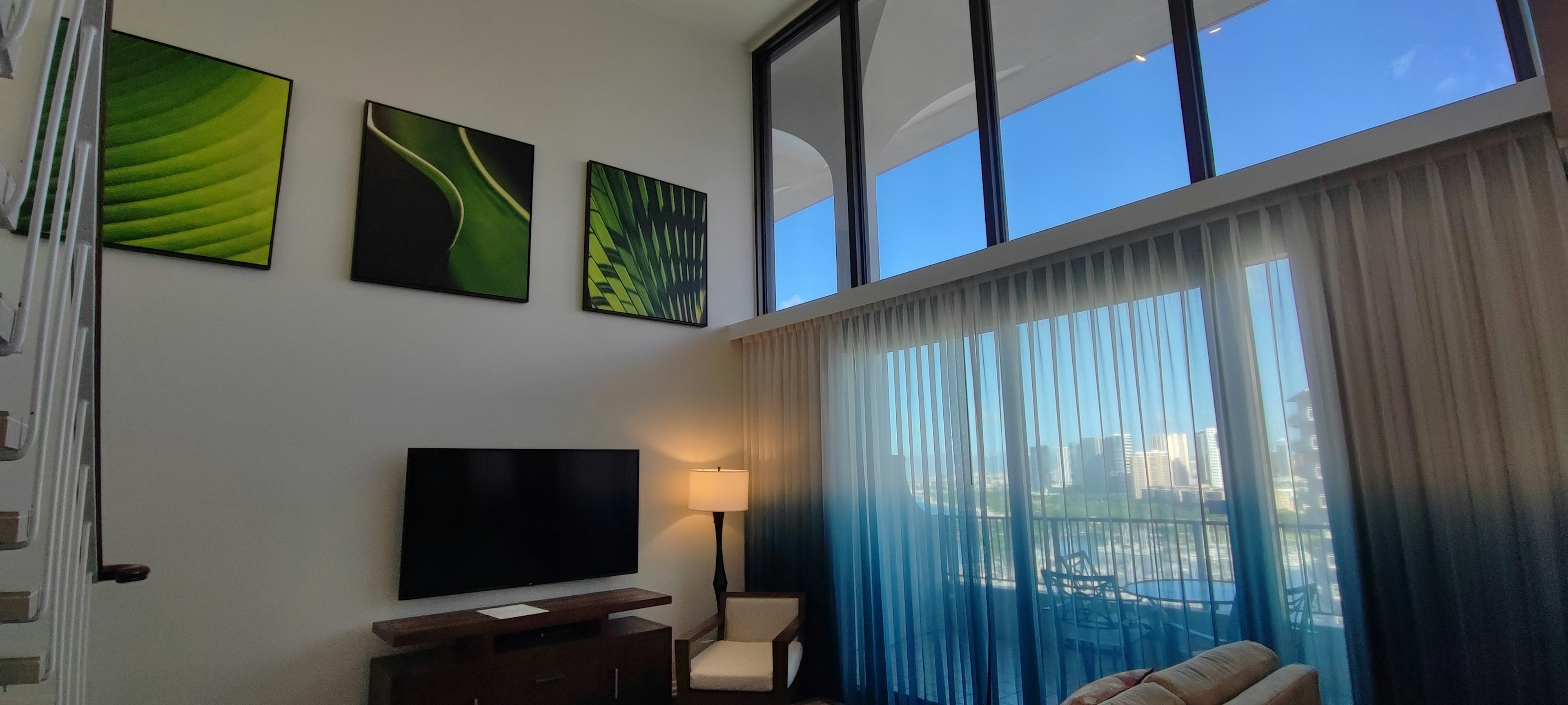 Bright living room featuring large windows and green artwork on the wall