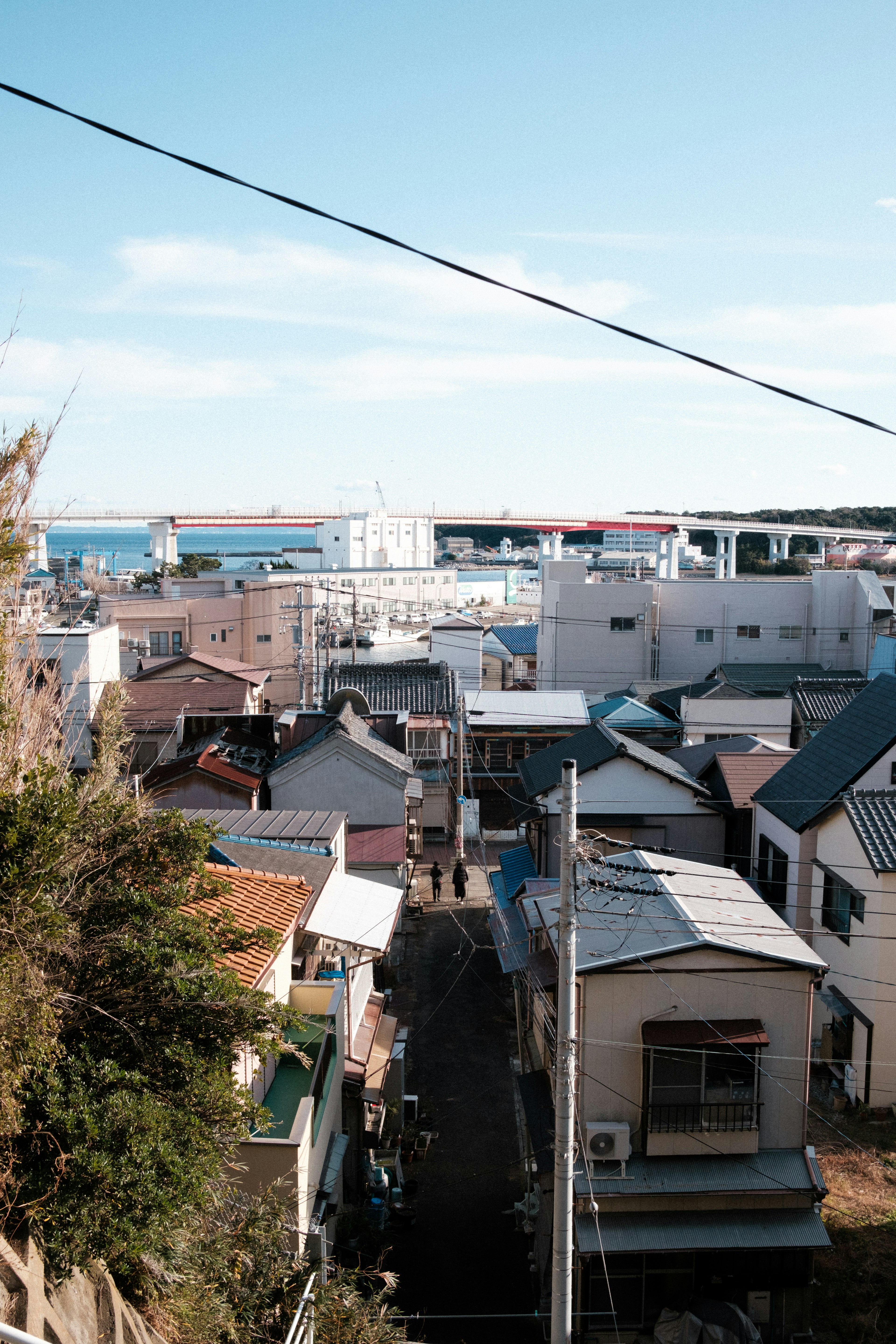 Vue d'un quartier résidentiel donnant sur le port avec ciel bleu et mer, maisons aux toits variés