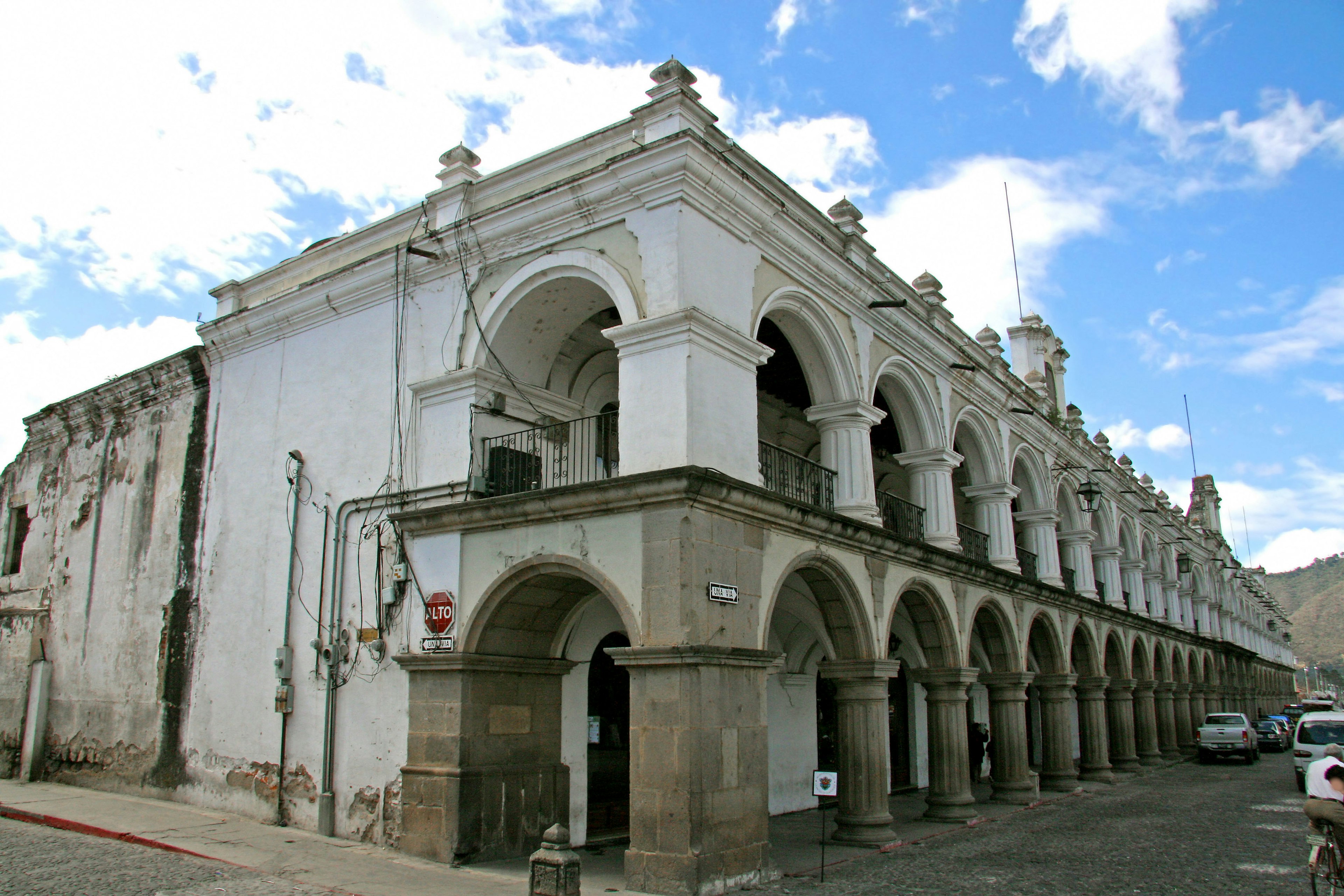 Colonial-style building with white arches and blue sky