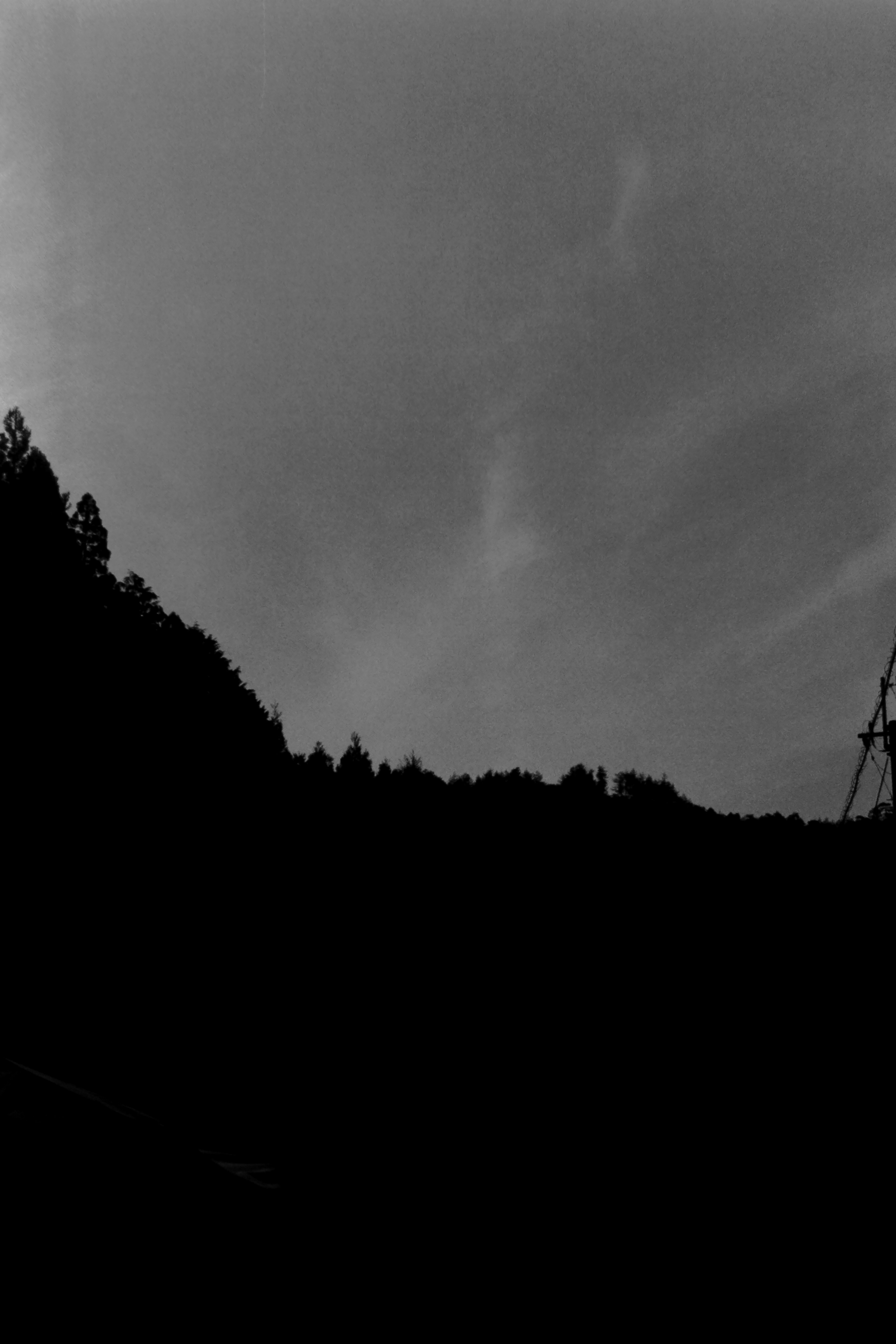 Silhouette of dark mountains against a cloudy sky